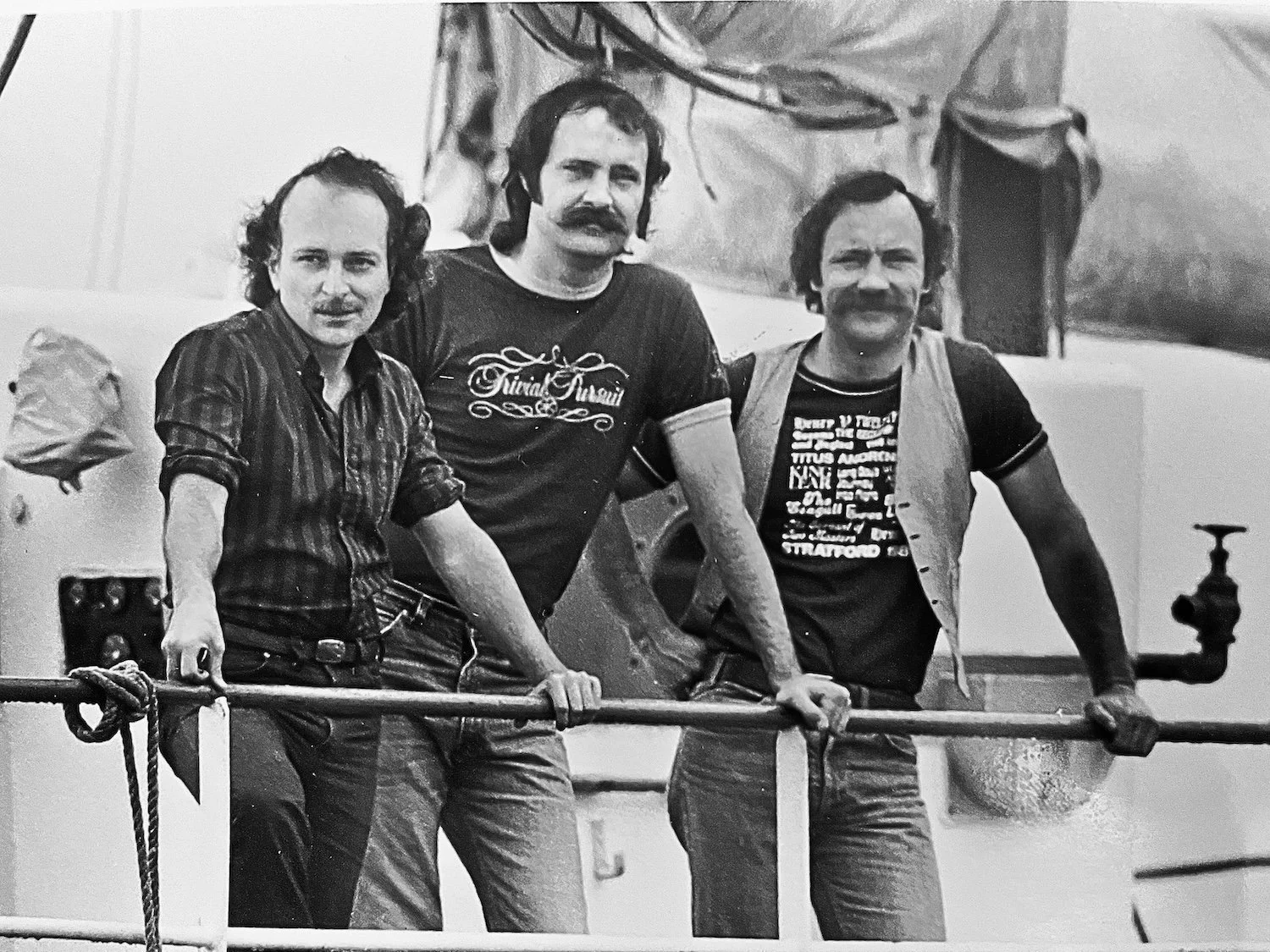Trivial Pursuit co-creators Scott Abbott, Chris Haney, and John Haney on a boat beside the Old Boat Works in Niagara-on-the-Lake, 1982.