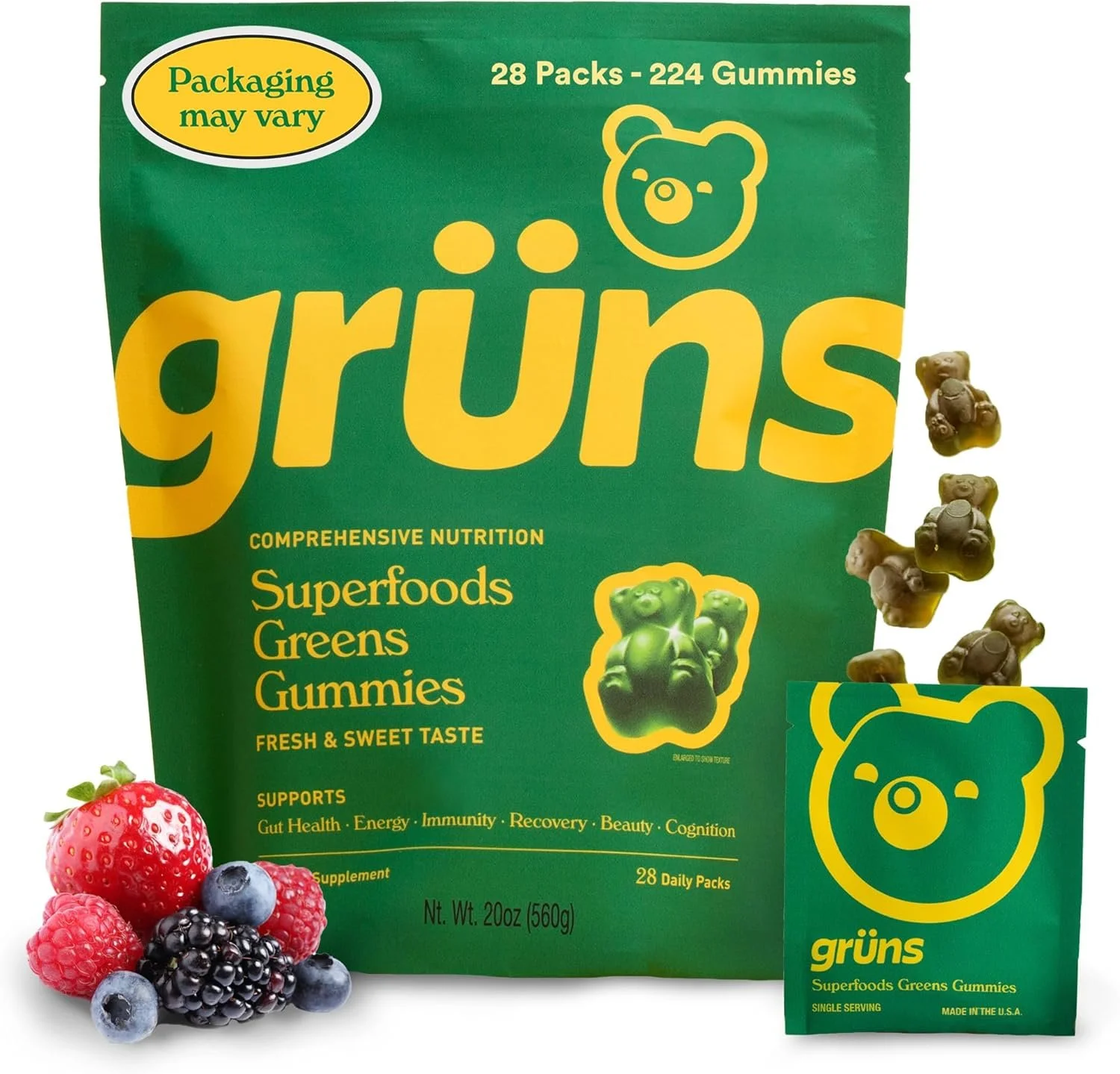 Green package of gummies with a bear logo, labeled 'grüns Superfoods Greens Gummies' with a smaller associated packet. The package states it contains 28 packs and 224 gummies, supports gut health, energy, immunity, recovery, beauty, and cognition, and weighs 20 ounces. There are mixed berry fruits in front of the package.
