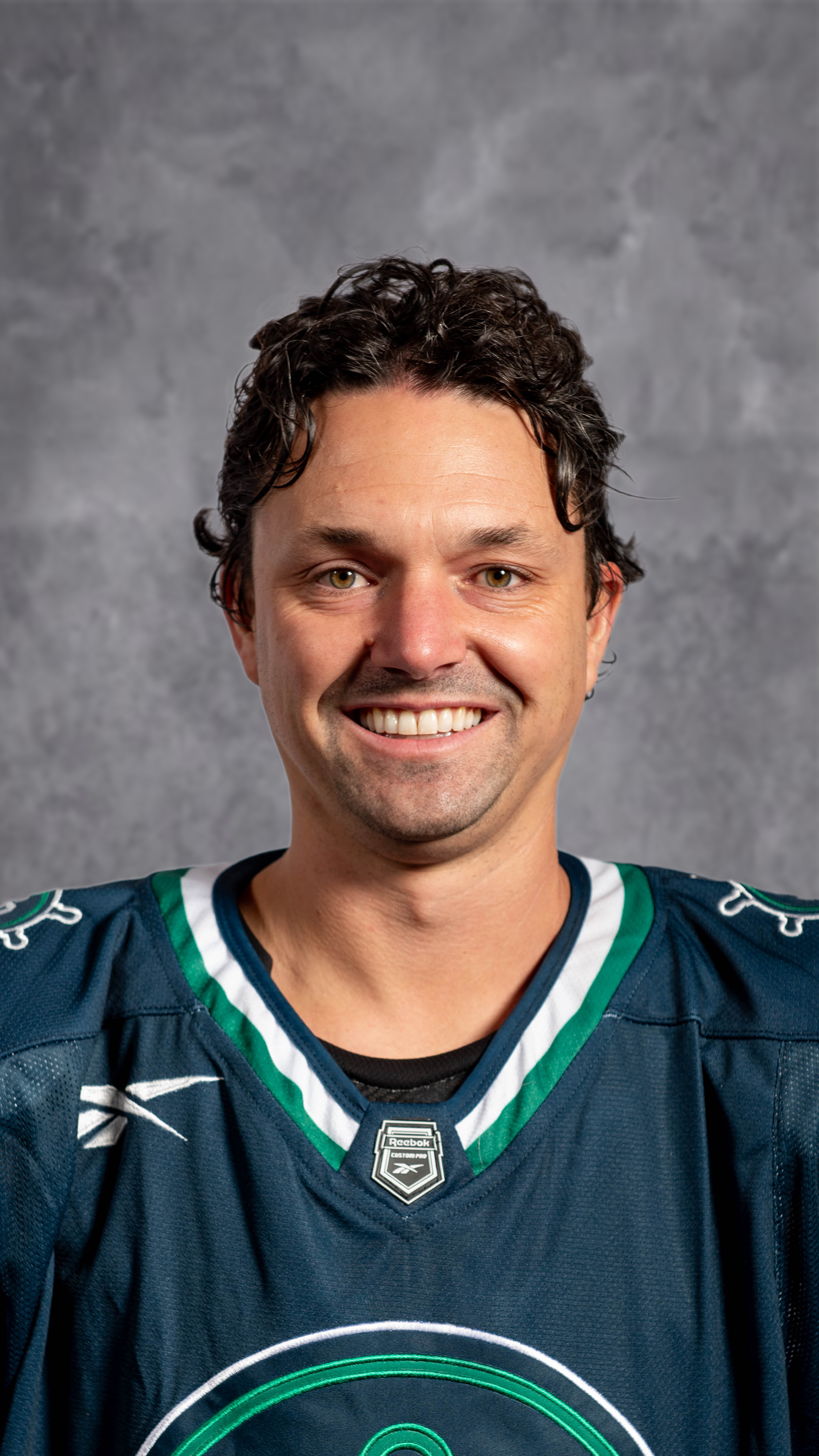 A logo featuring a green anchor with two lion figures, a map outline behind it, and a circular border.