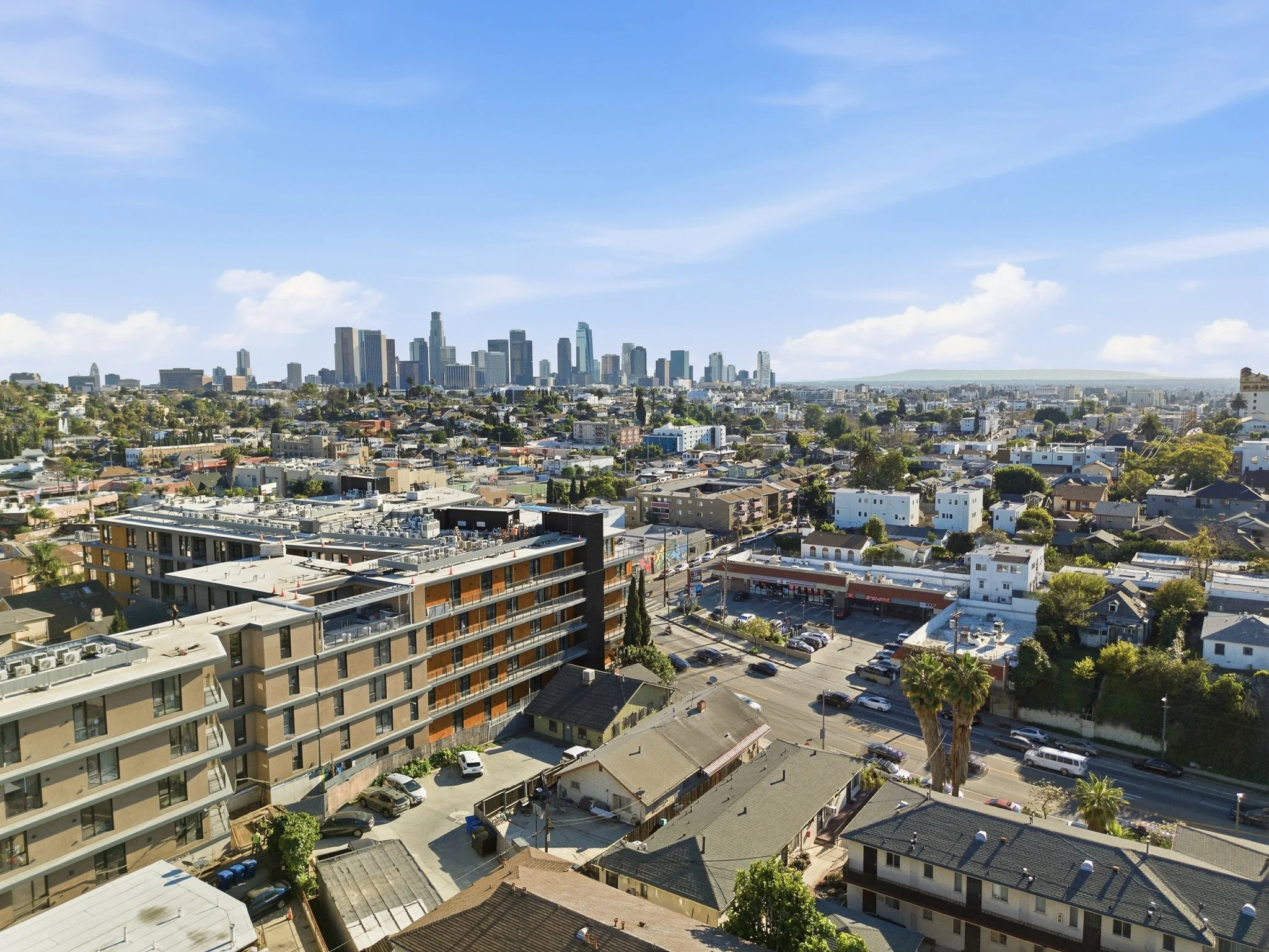 Cityscape with downtown skyscrapers and residential neighborhoods during the daytime, under a clear blue sky.