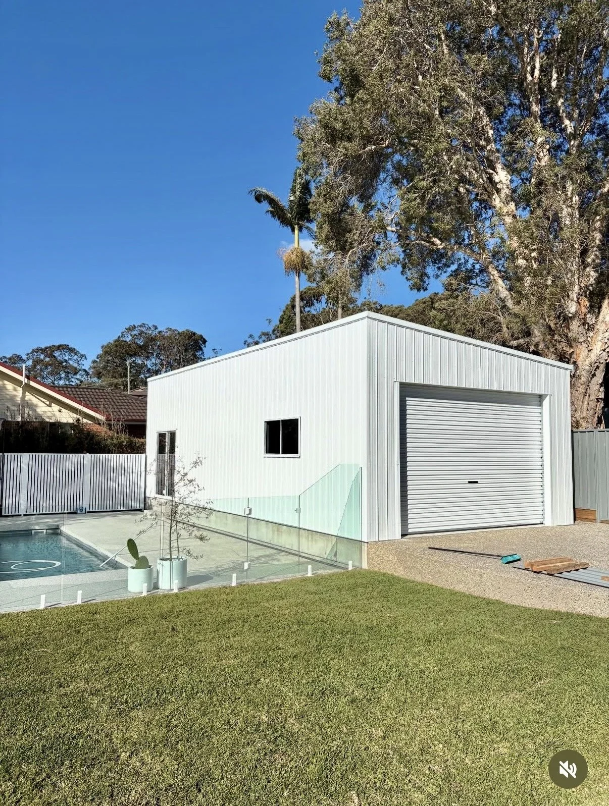 Dover white shed with a garage door and small windows and side access door.