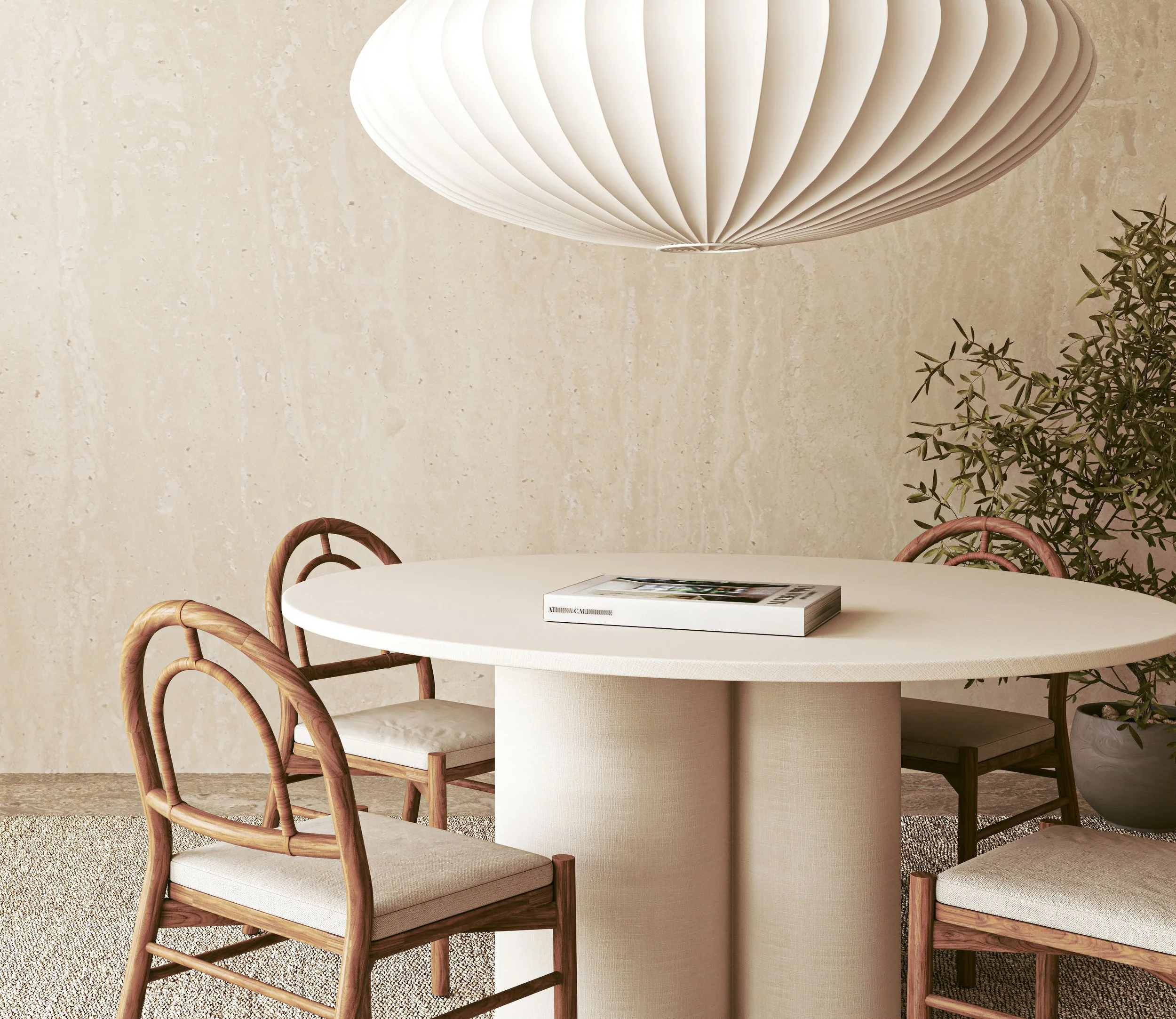 Scene of a minimalist dining area with a white round table, wooden chairs with woven backs, a white paper lantern ceiling light, a beige textured wall, and a potted plant.