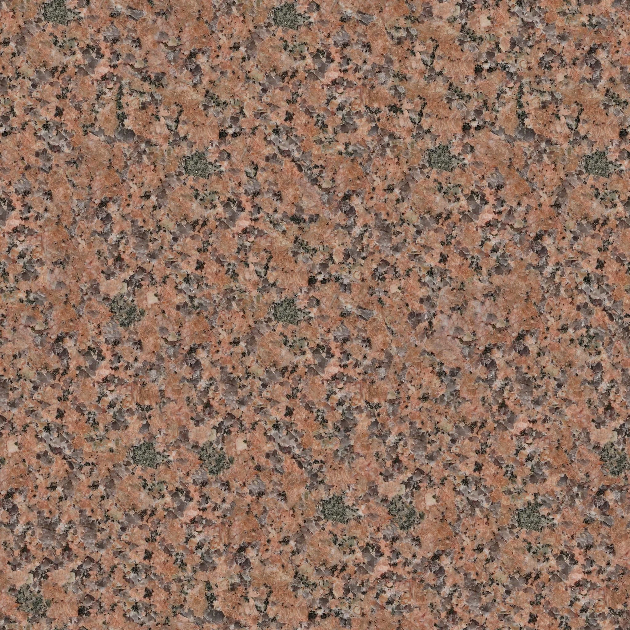 Close-up of polished pink granite stone with black, gray, and green mineral flecks