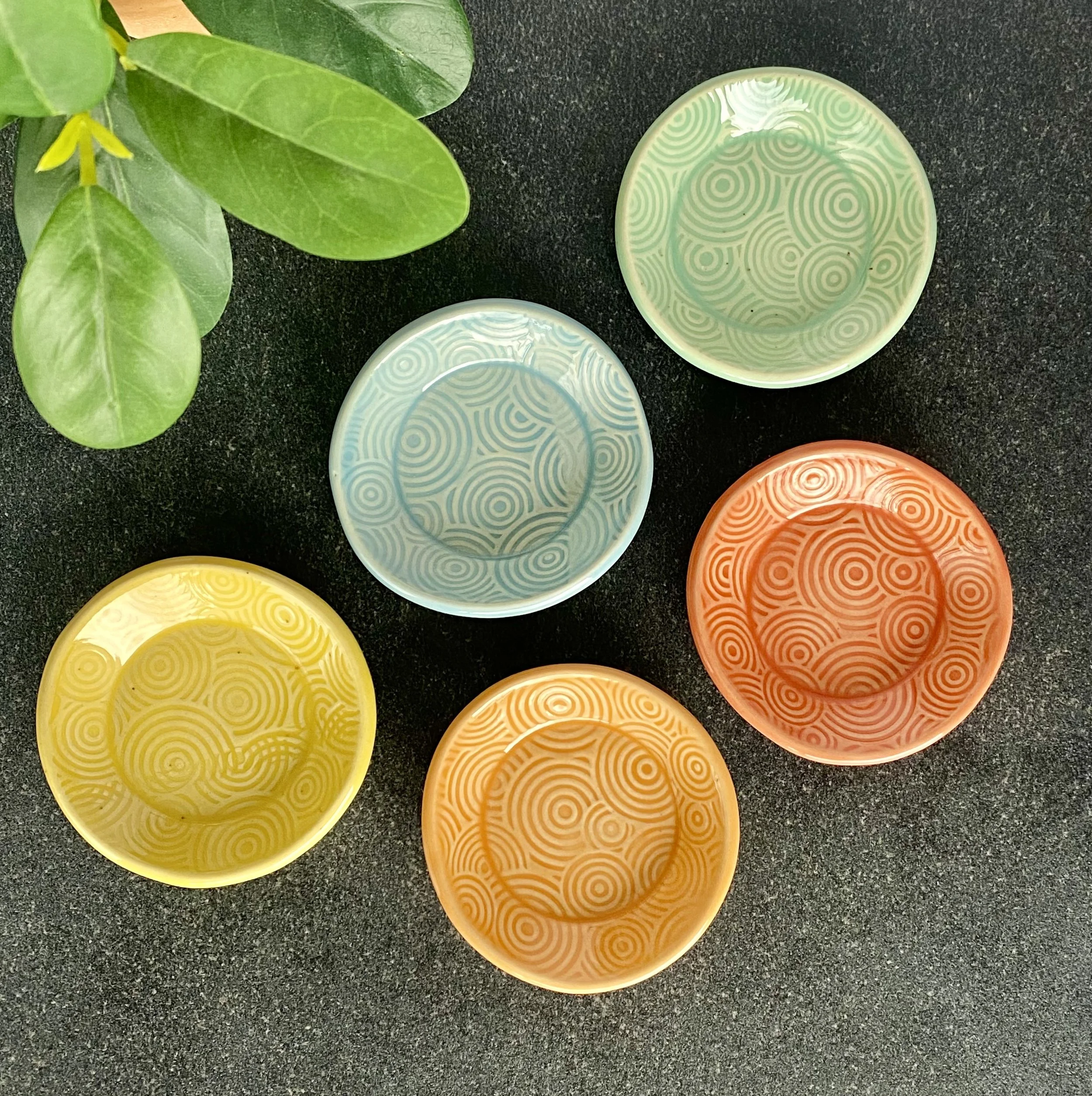 Colorful slab-built round jewelry and trinket ceramic dishes with spiral patterns