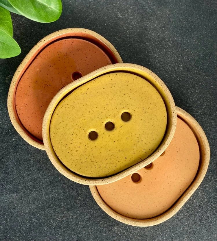 Three oval soap dishes with draining trays