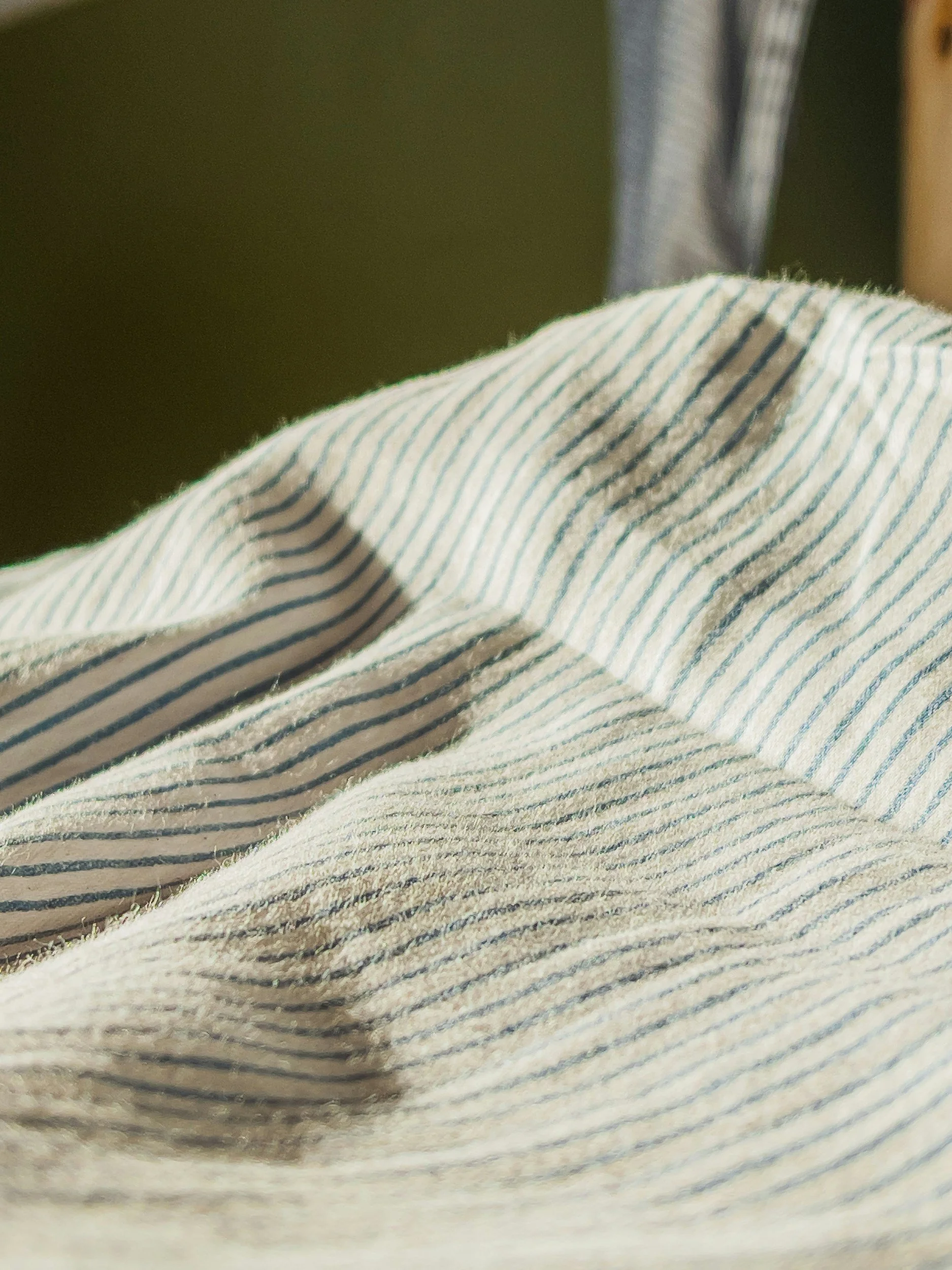 Close-up of a fabric with blue and white pinstripes, showing the texture and pattern.