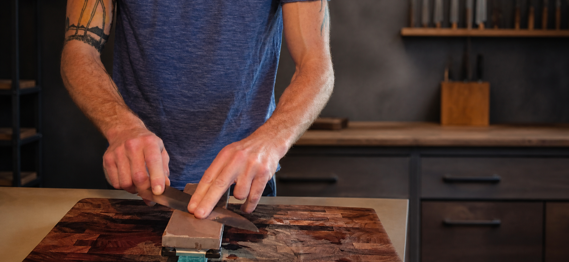 Craftsman sharpening a kitchen knife by hand on a Japanese waterstone.