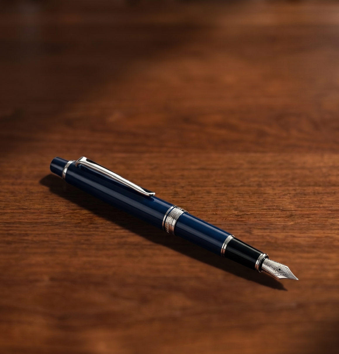 A blue and silver fountain pen resting on a wooden surface.