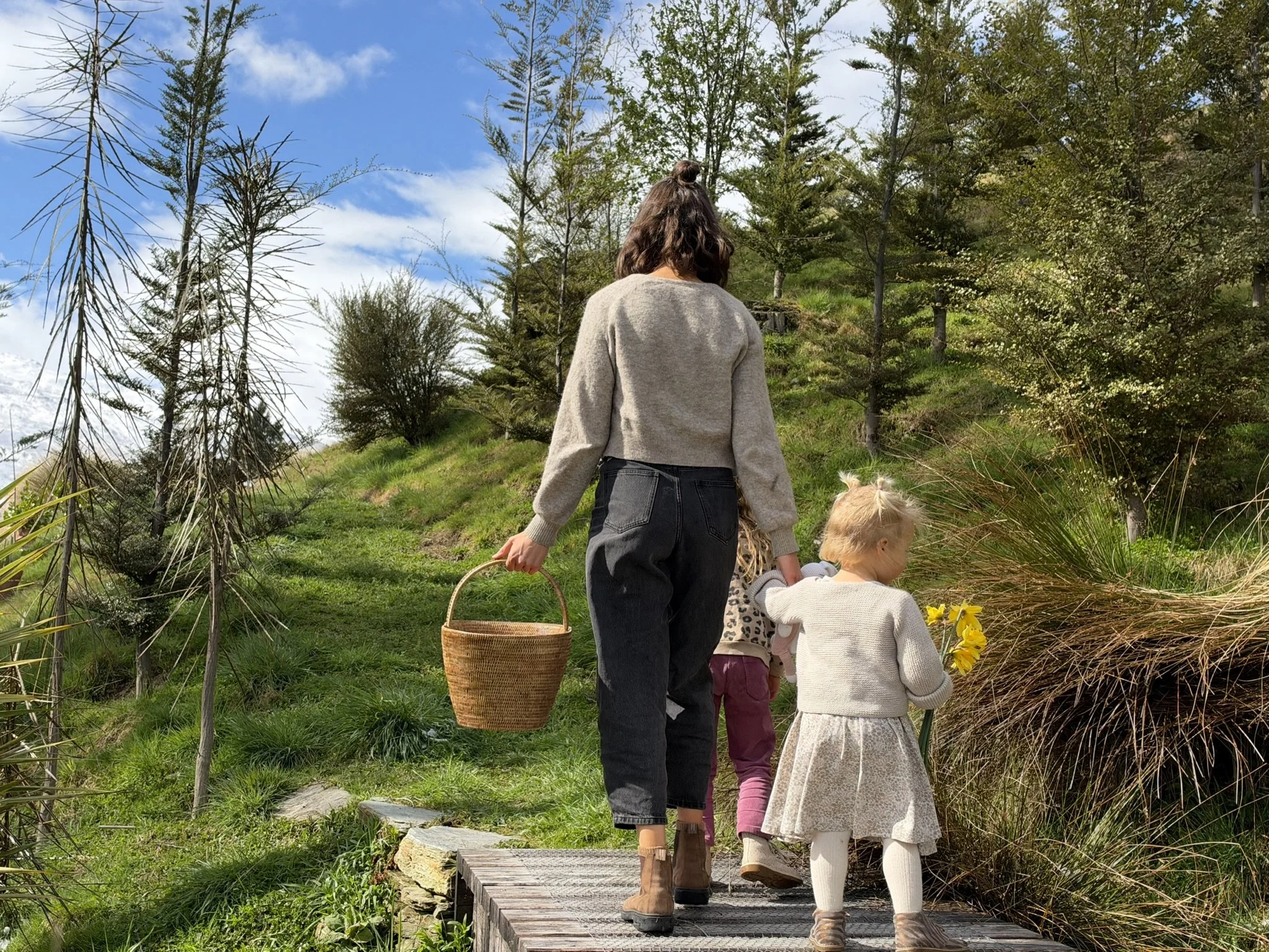 Georgie and her daughters walking through their garden together.