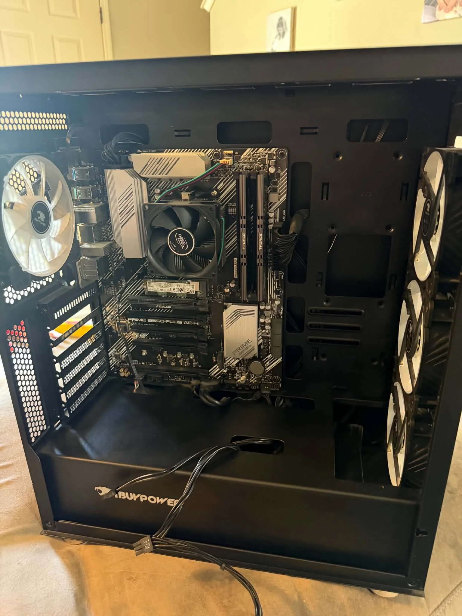 Interior view of a black computer case with visible motherboard, CPU cooler, RAM sticks, and cooling fans.