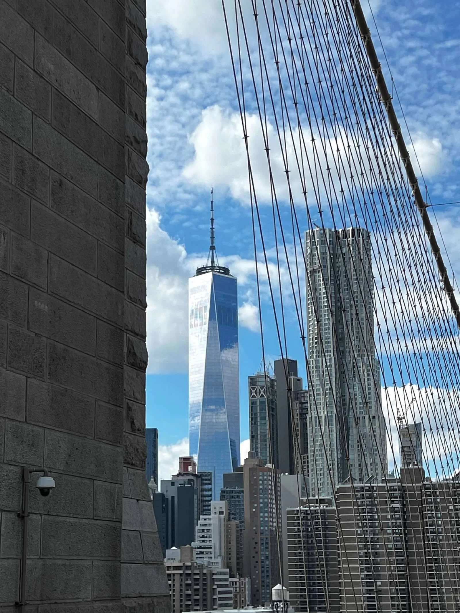 Brooklyn Bridge cables with the New York City skyline and One World Trade Center