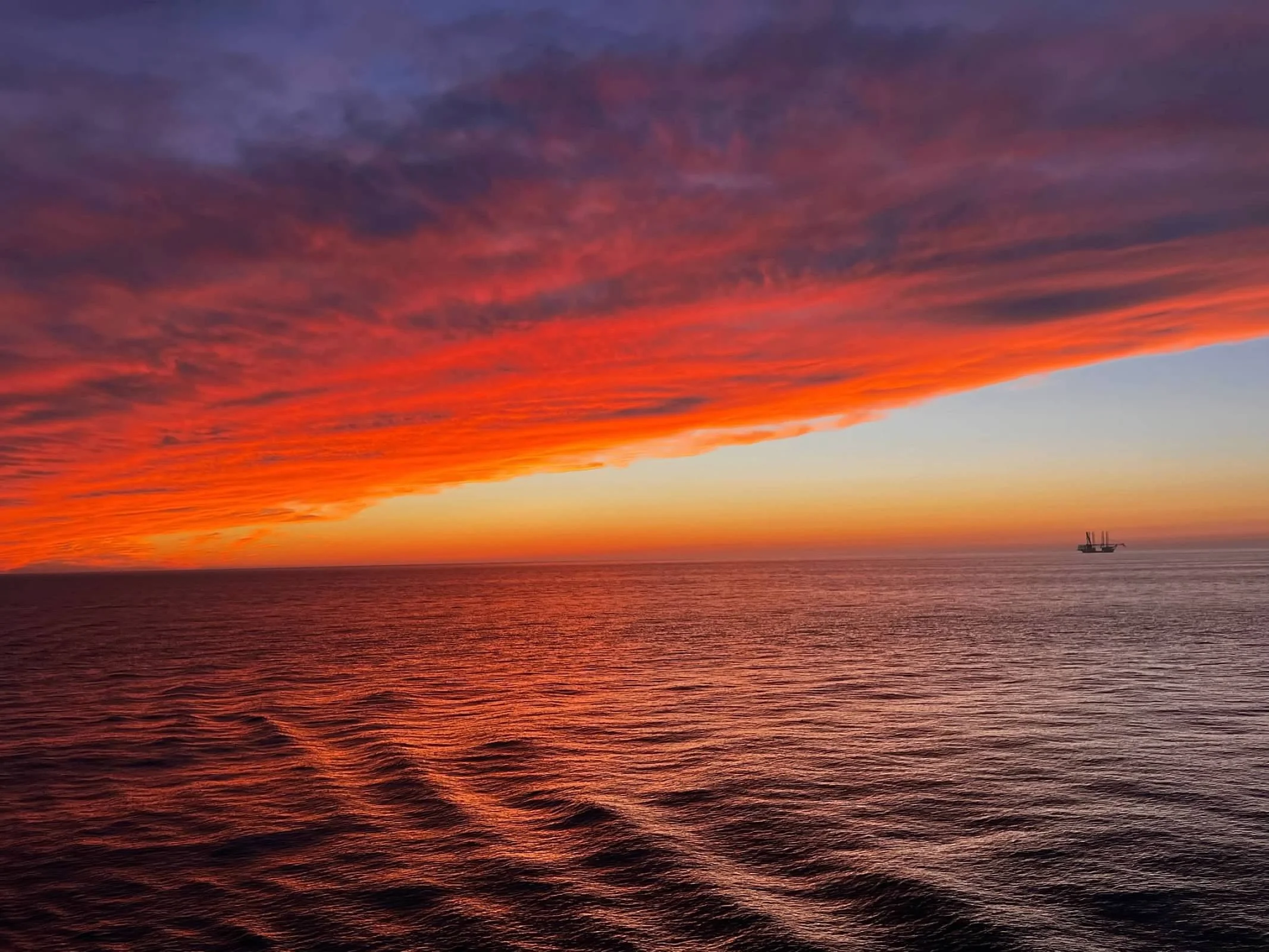 Fiery orange and red sunset over the open ocean at sea on a cruise