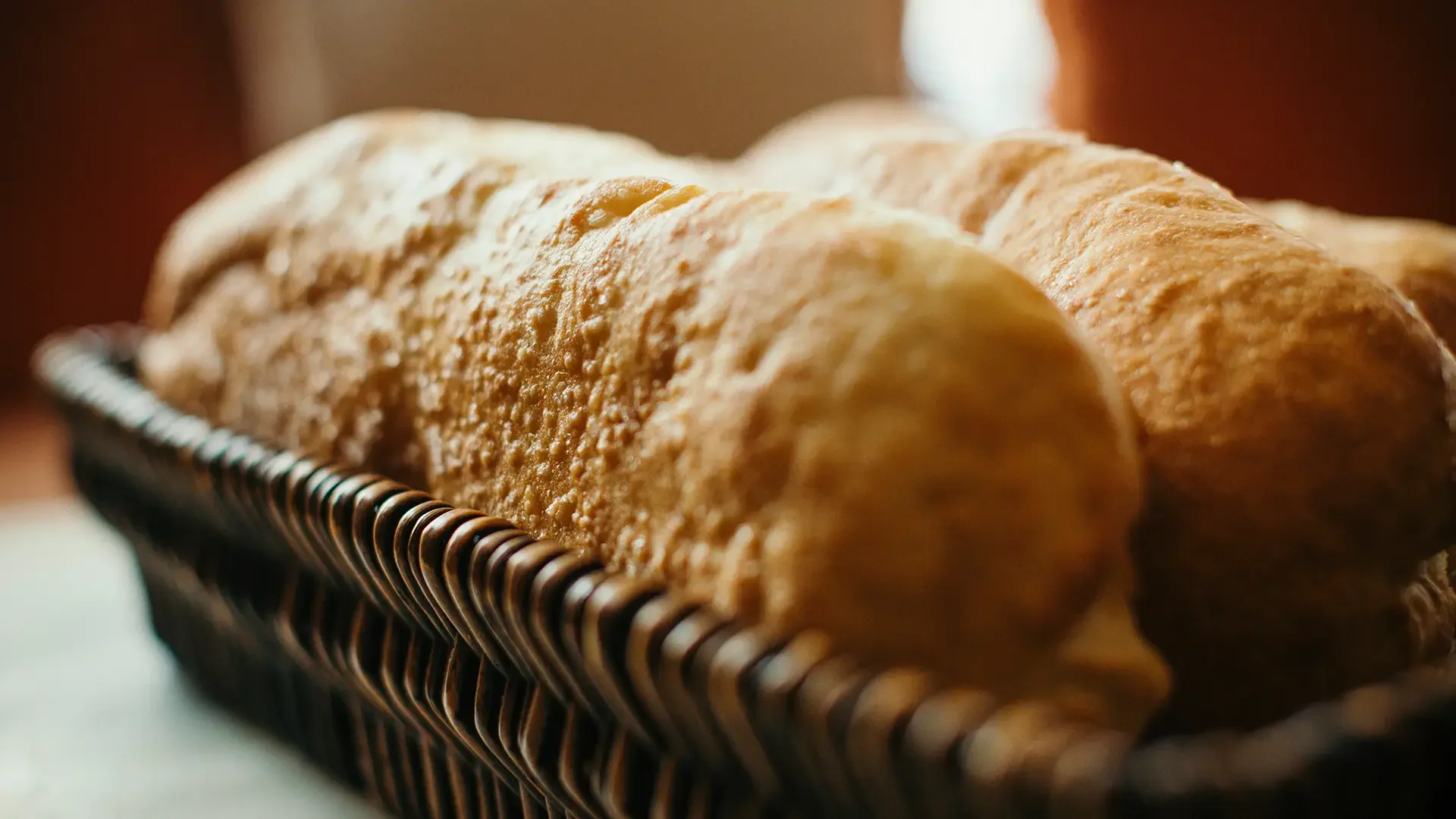 Close-up of freshly baked baguettes in a basket made at Warfield's bakery in Clifton Springs, NY, with a blurred background.