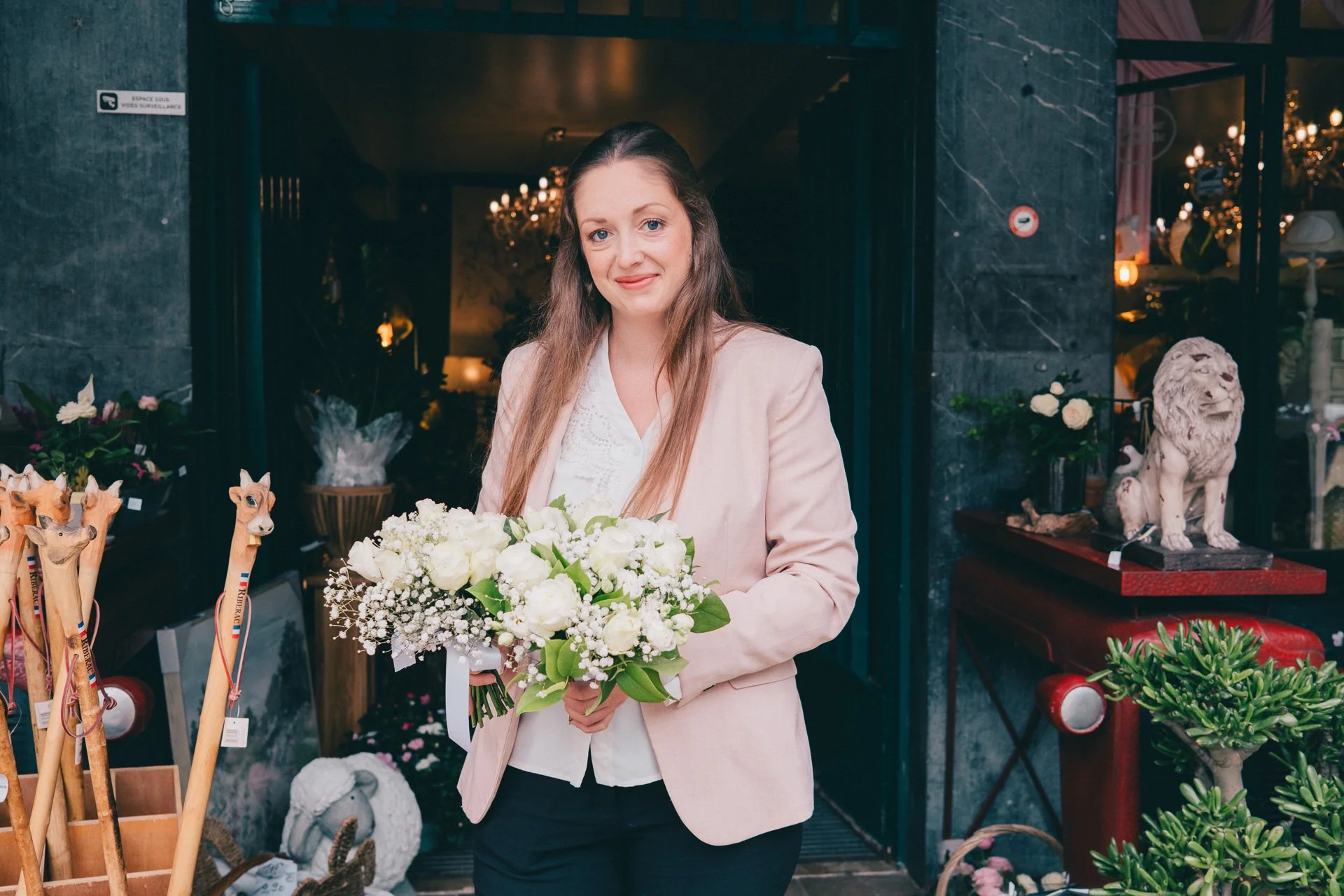Femme tenant un bouquet de fleurs dans une boutique.