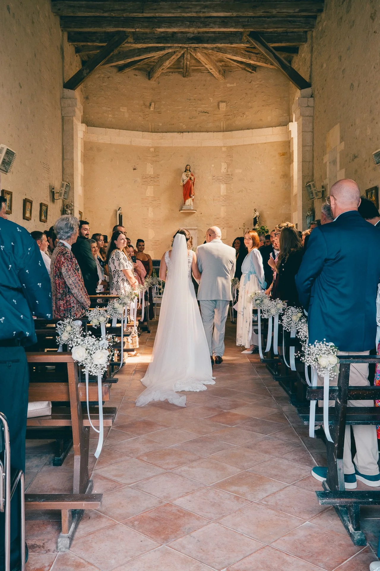 Cérémonie de mariage dans une église avec un couple à l'autel entouré d'invités.