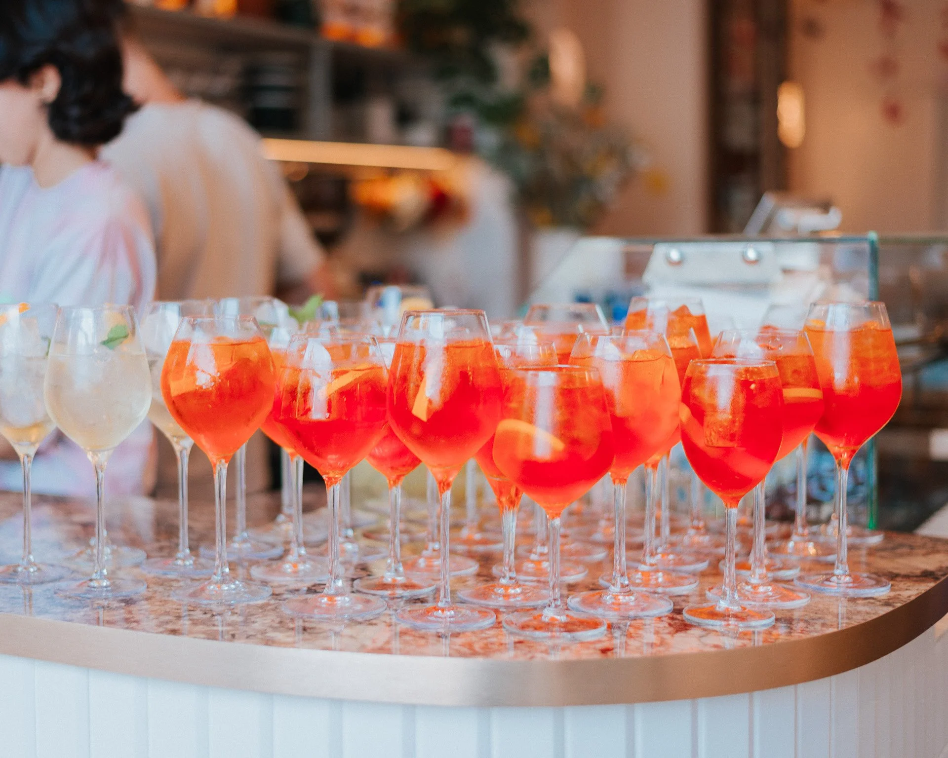 Verres de cocktail orange sur un comptoir de bar.