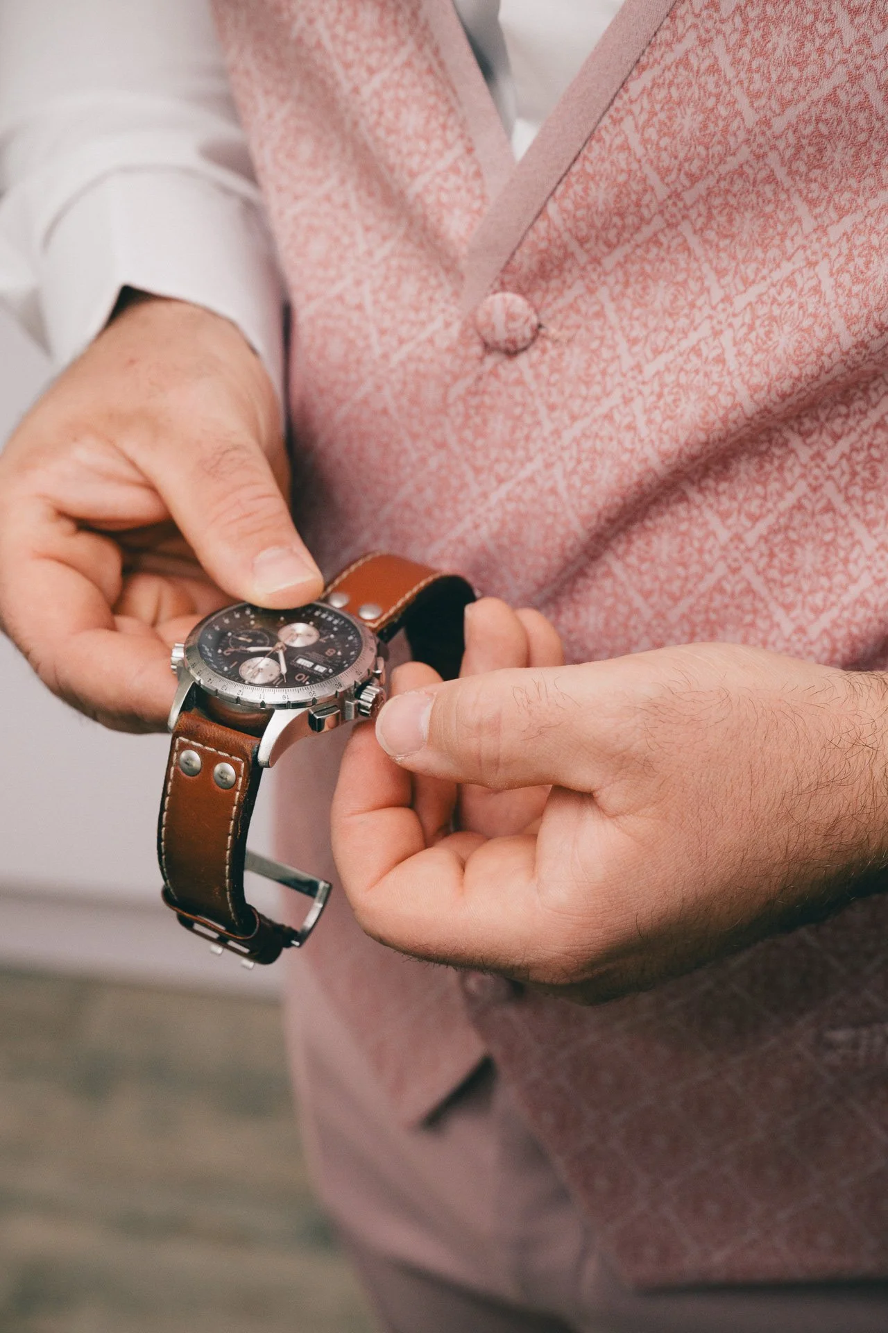 Une personne ajustant une montre-bracelet avec un fond flou.