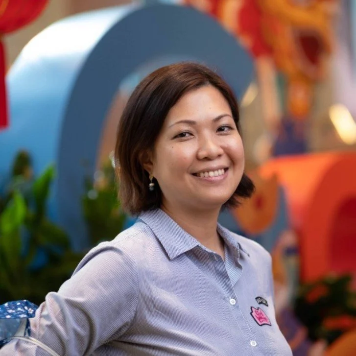 Smiling person in a striped shirt, embracing a career switch amid vibrant hue | Ctrl Alt Career