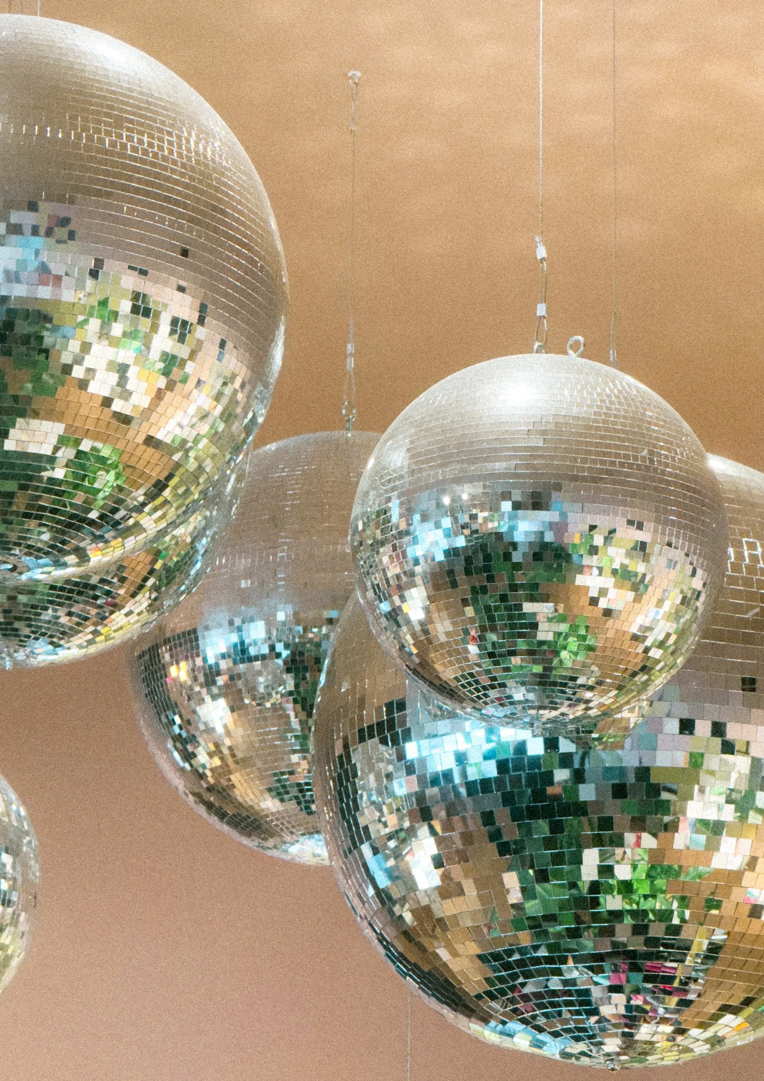Multiple disco balls hanging from the ceiling, reflecting light and creating a sparkling effect.