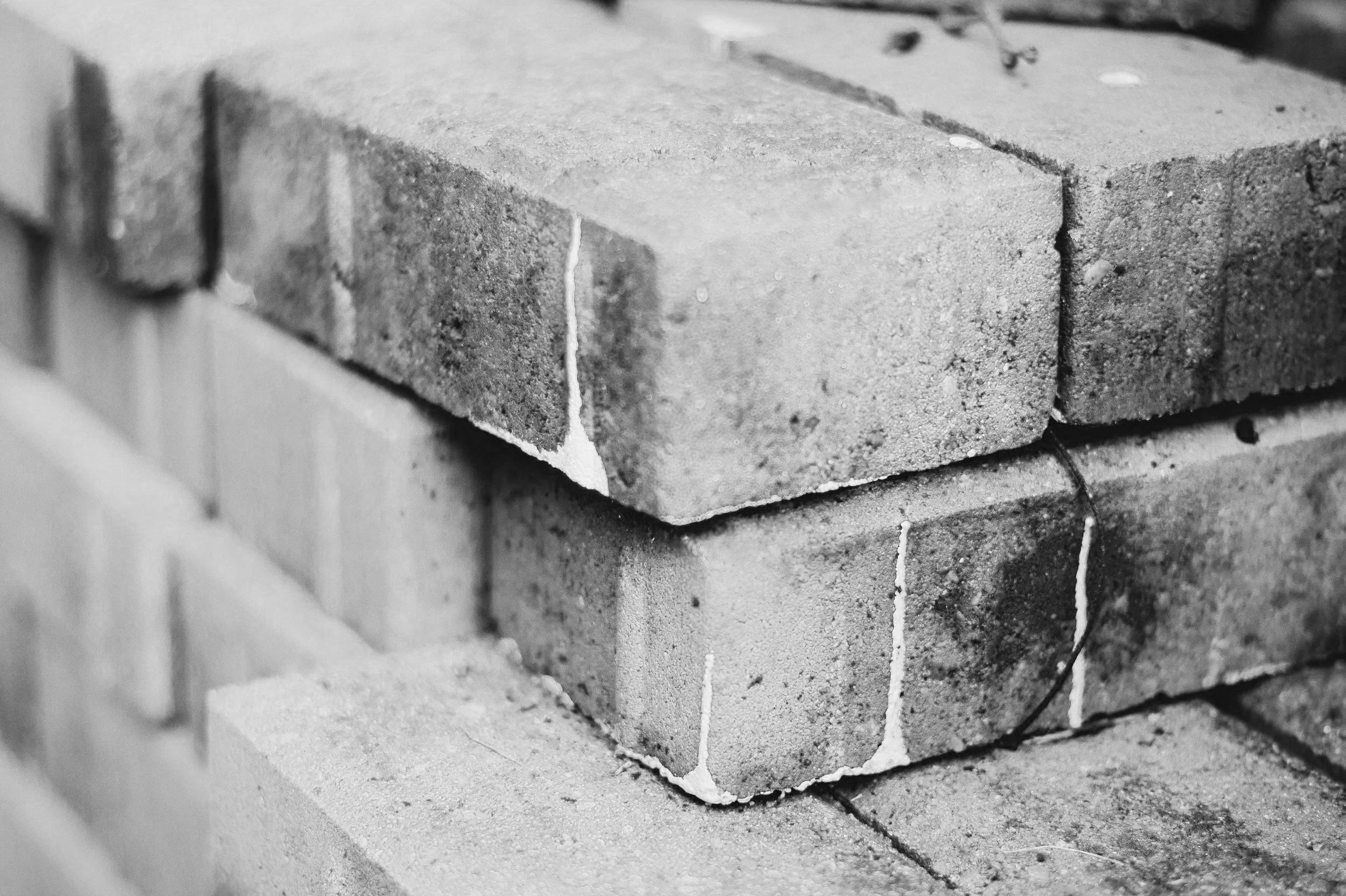 Close-up of bricks in a masonry wall, showing the texture and mortar lines between the bricks.