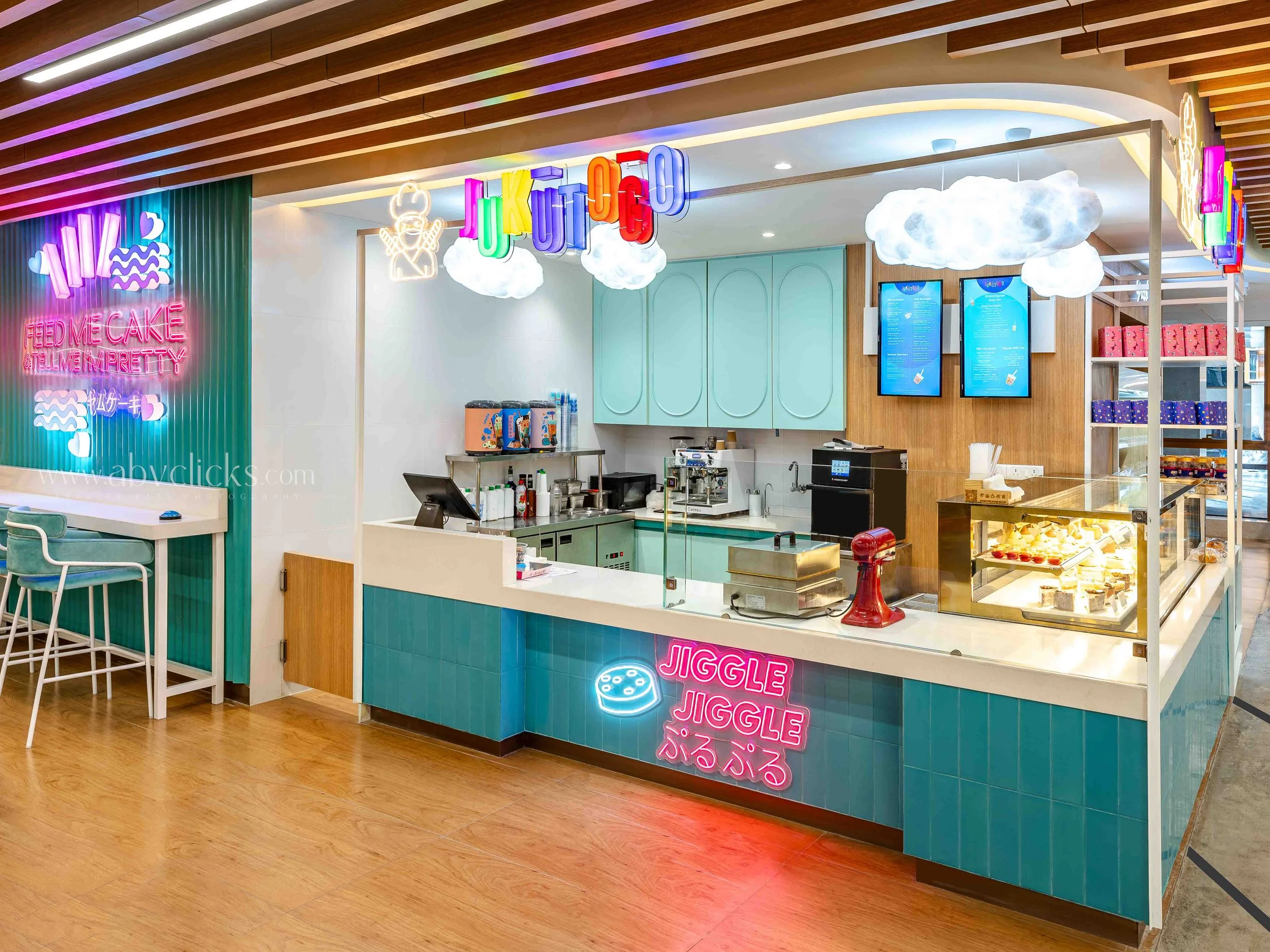 Colorful ice cream shop with neon signs, clouds, and rainbow lighting fixtures.