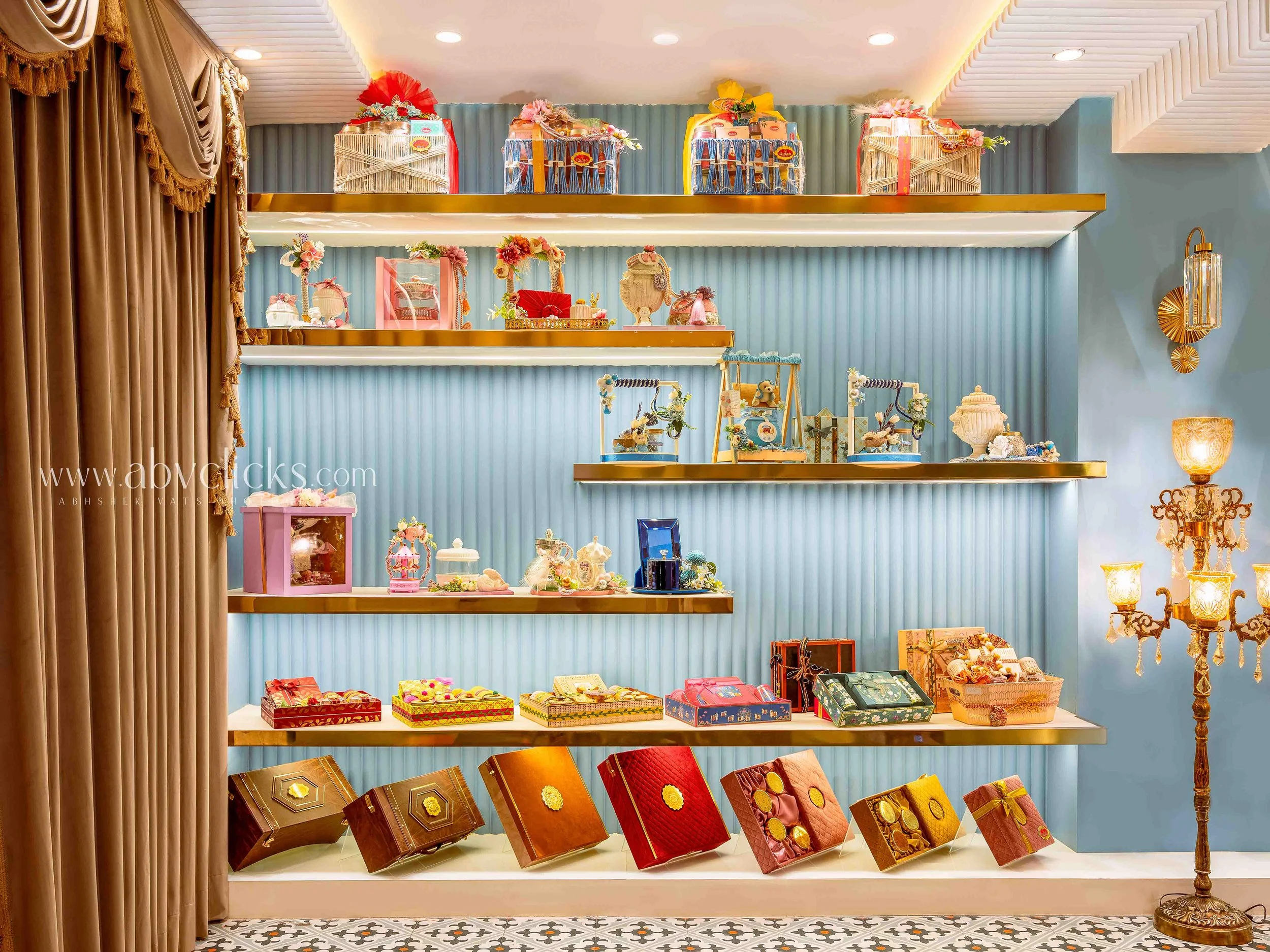 Display of decorative gift boxes and jewelry on shelves in a boutique or gift shop.