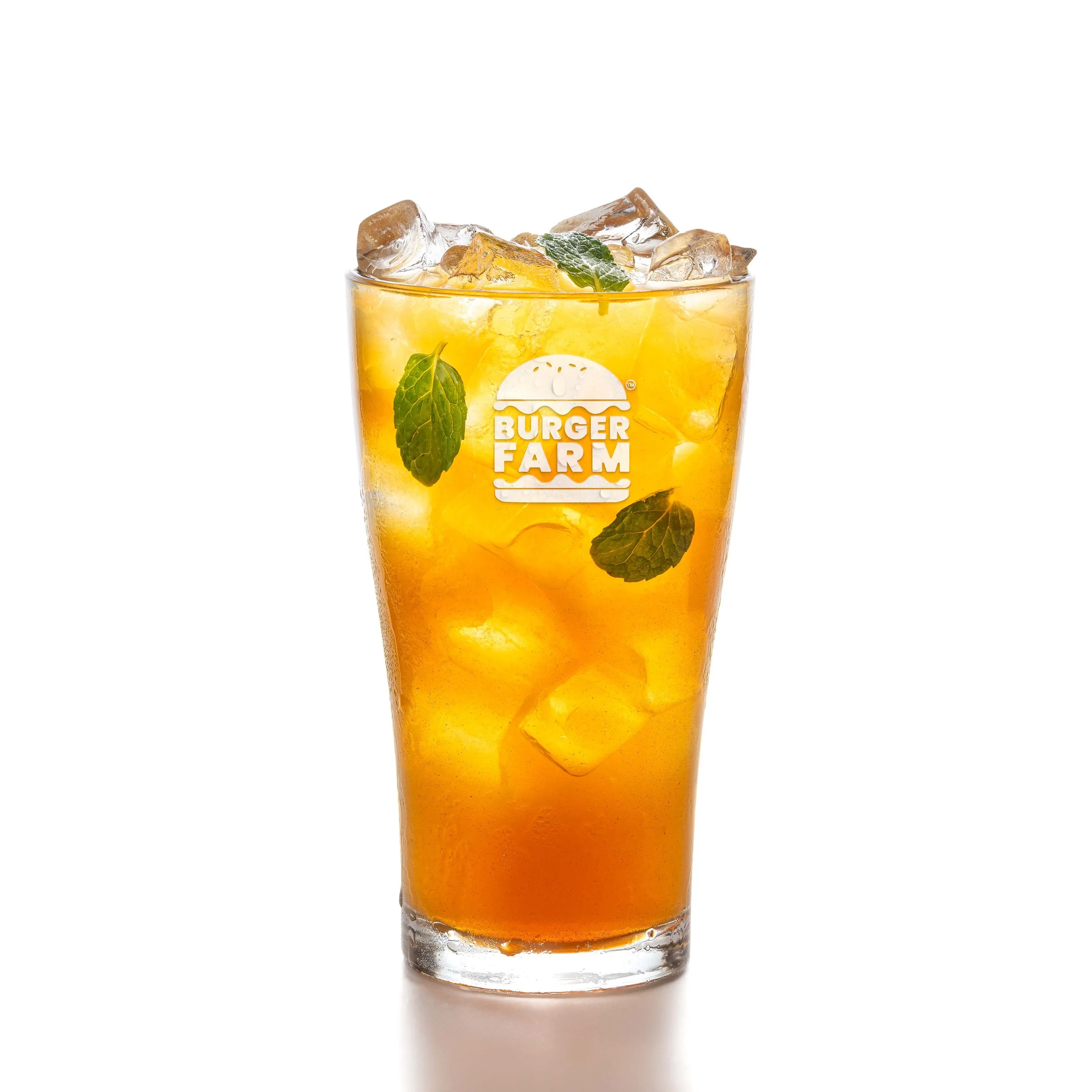 A glass of iced tea with ice cubes and fresh mint leaves on top, with a white background.