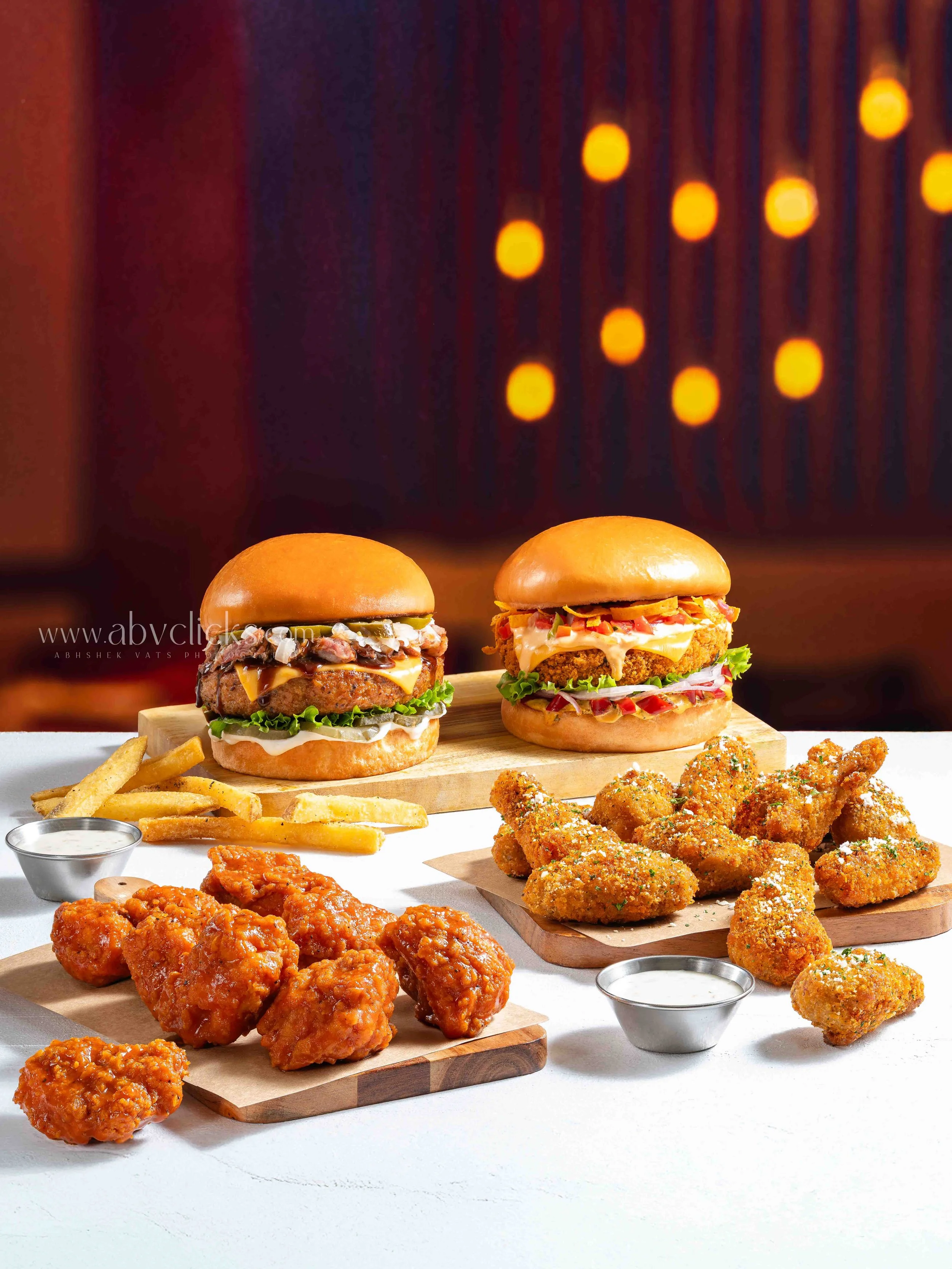 For Brand Chili's, Assorted fried chicken pieces, french fries, and mini sliders with various toppings and sauces, served with dipping sauces.