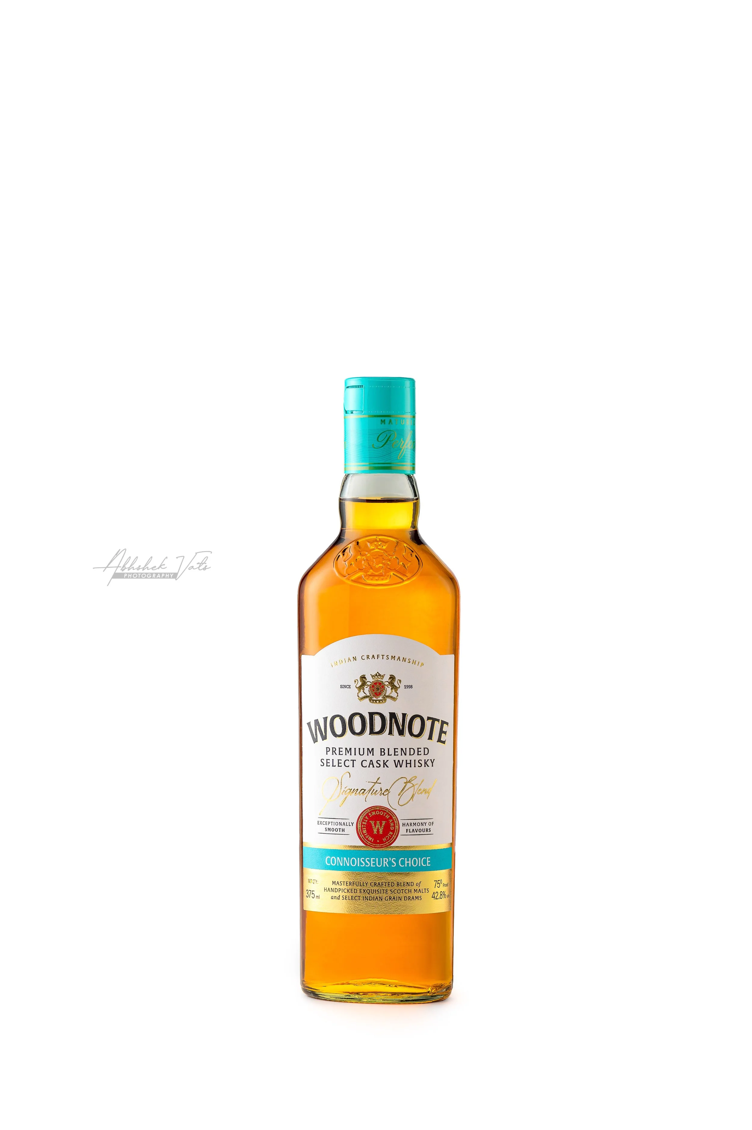 Bottle of Woodnote premium blended whisky with a light amber color, clear label, and turquoise cap.