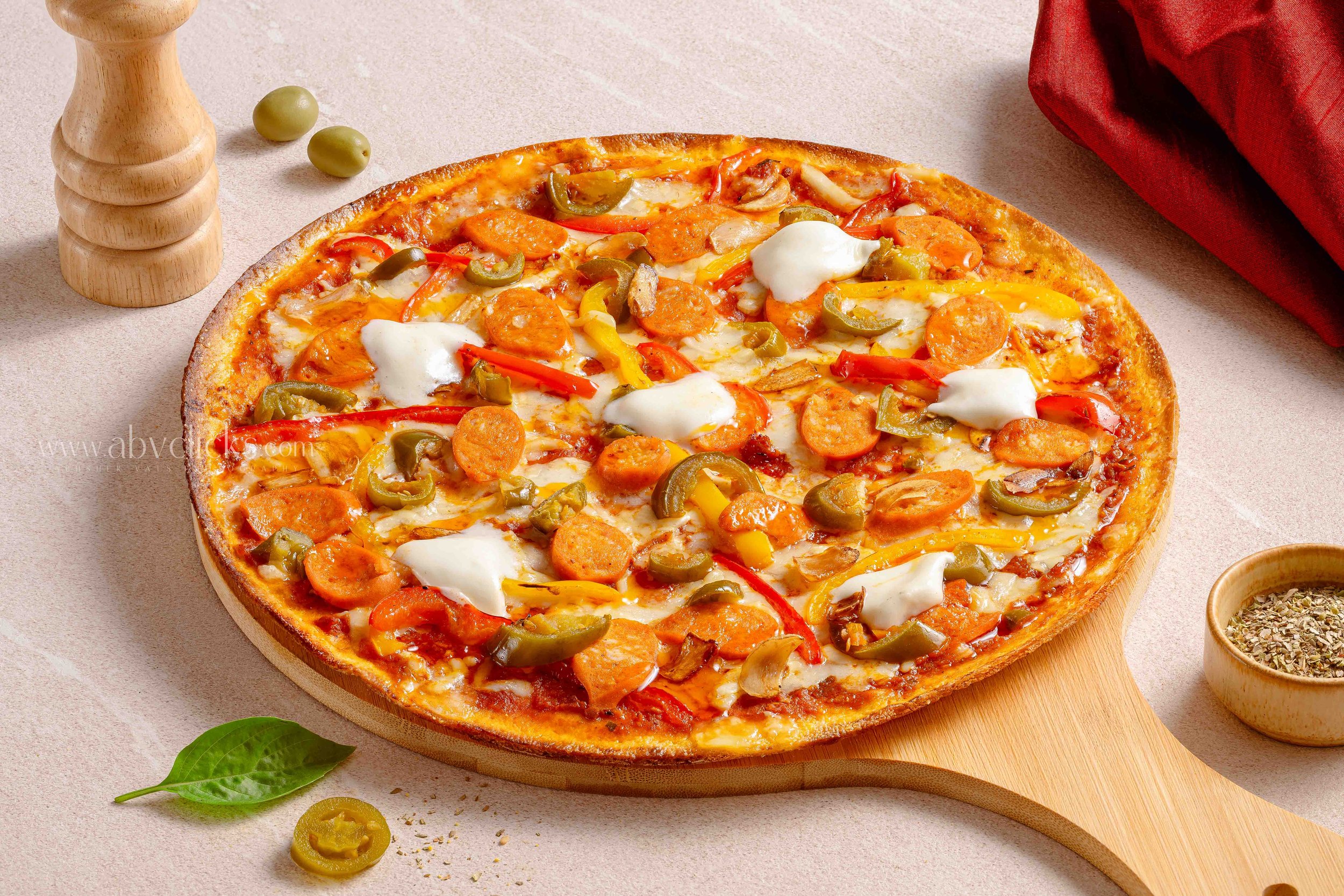 A pizza with pepperoni, sliced bell peppers, jalapenos, and melted cheese on a wooden board.