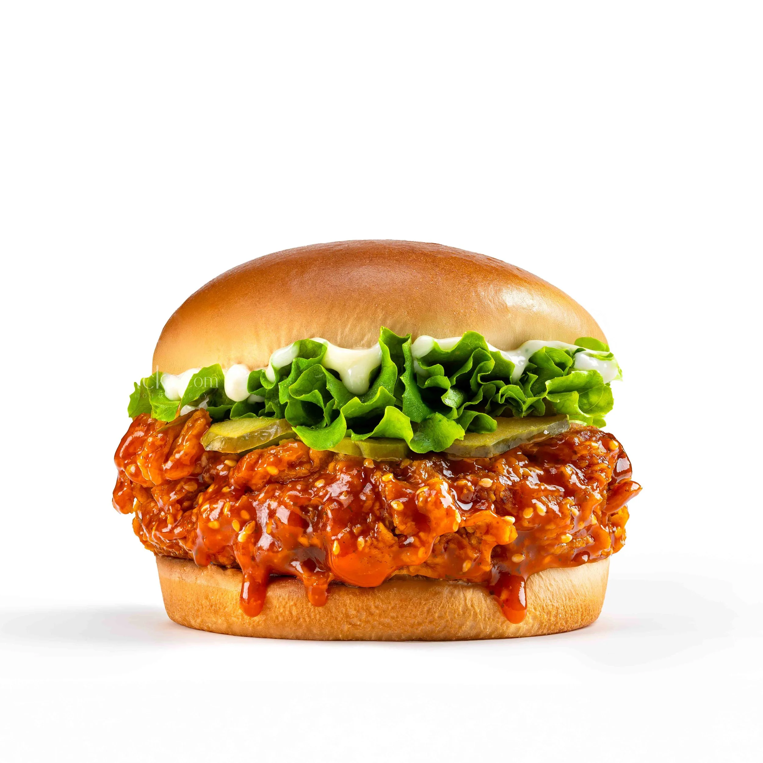 Close-up of a burger with a bun, lettuce, pickles, spicy sauce, and possibly chicken or pork patty, on a white background.