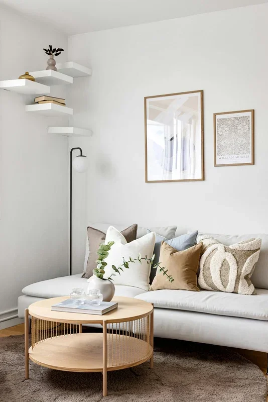 Calm organised living room with a neutral sofa and round coffee table