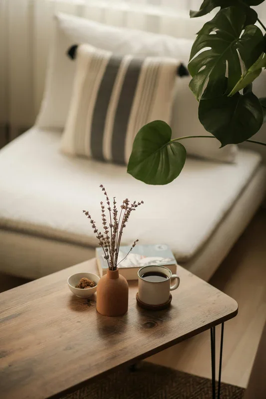 Calm living room with a wooden table, cup, vase and green houseplant