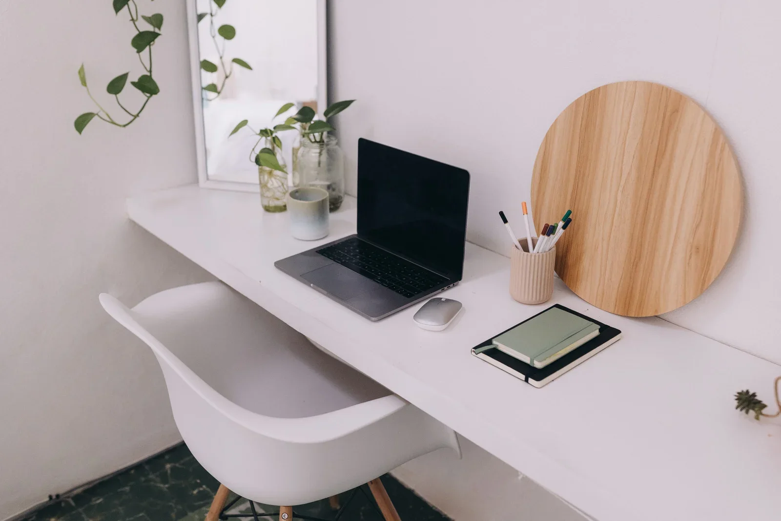 Minimal home workspace with laptop, plants and natural wood details