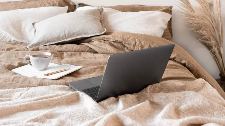 laptop on unmade bed