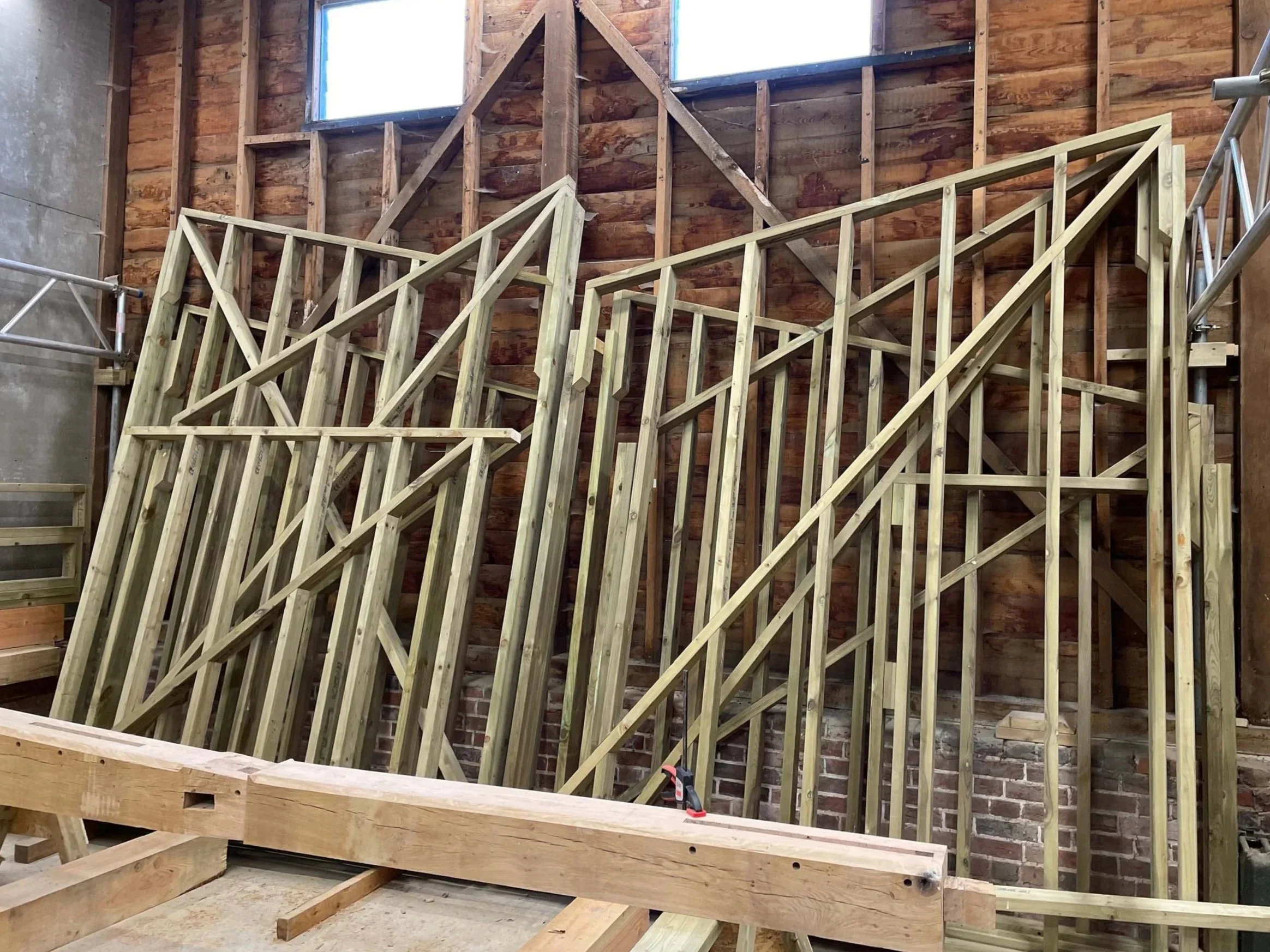 An image of timber beams being assembled for building a car garage.