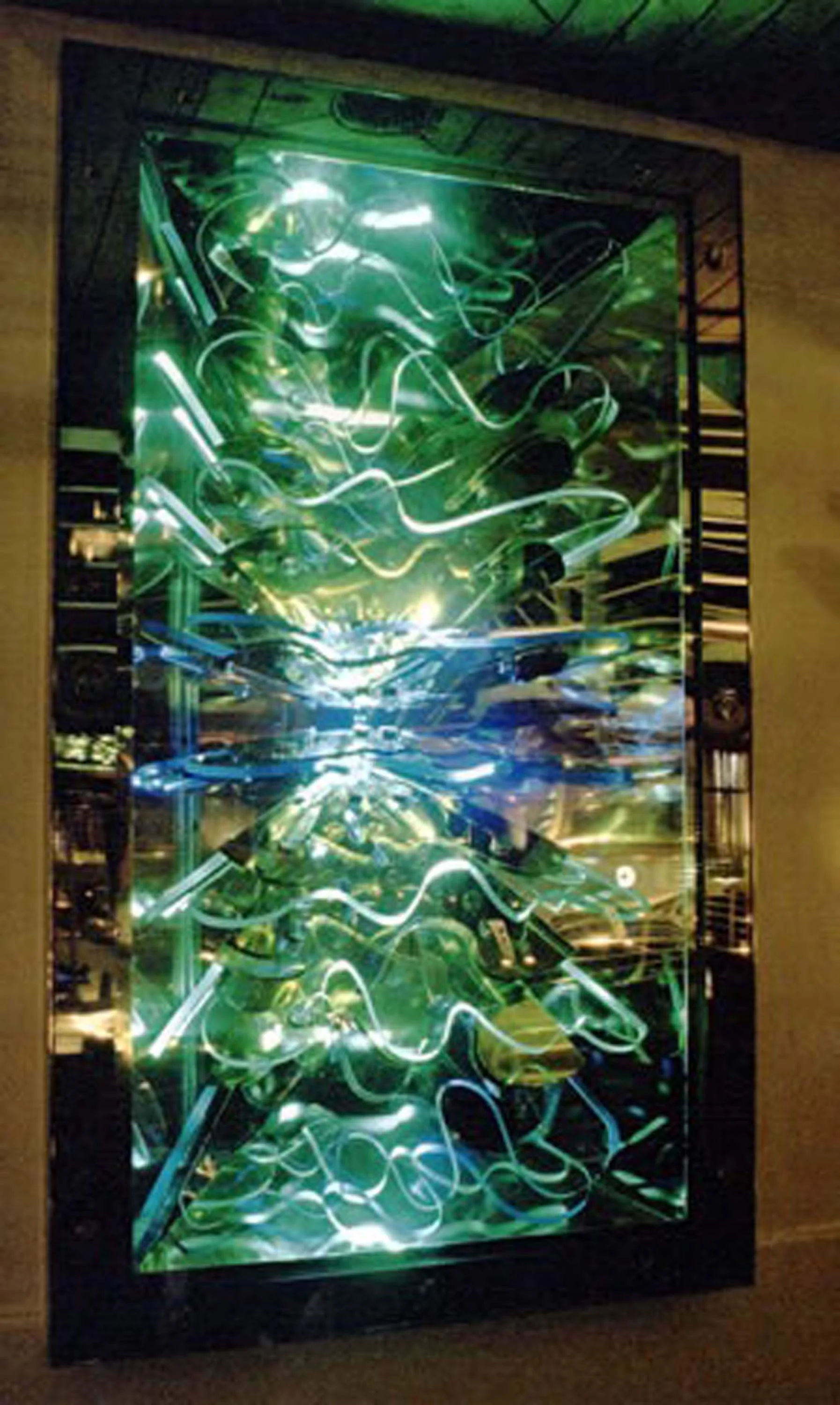 Colorful light installation with swirling neon lights inside a black frame, creating an abstract glowing pattern.