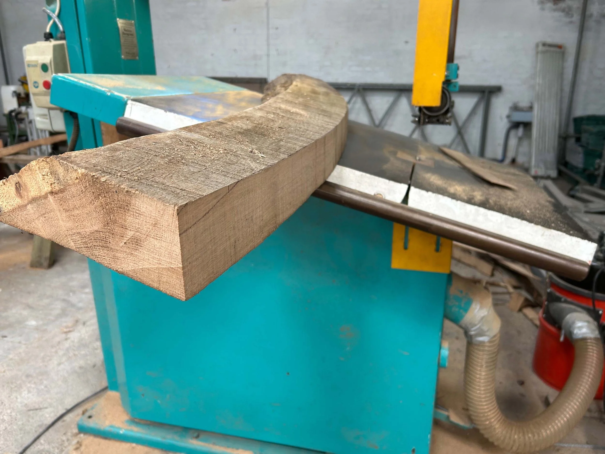 An image of a bandsaw cutting oak.
