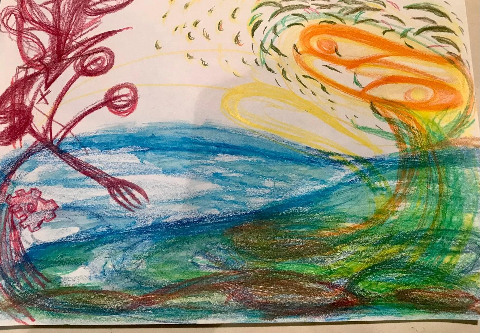 Colorful crayon drawing depicting a tree and a large swirling sun in the sky with water and grass in the foreground.
