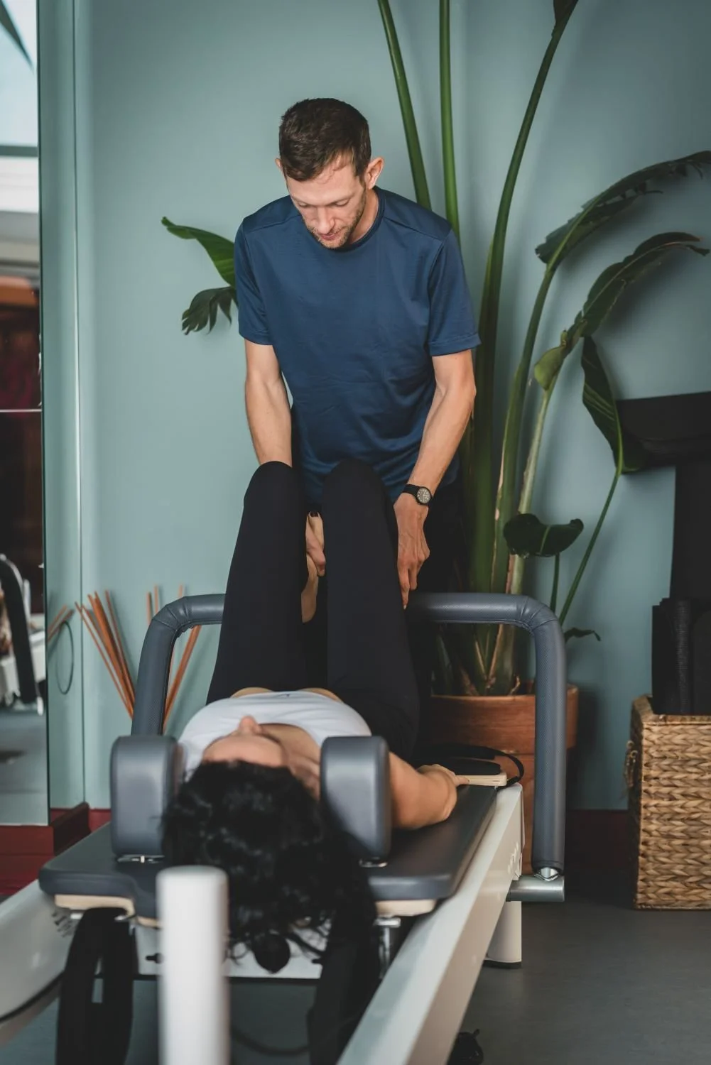 Insegnante di Pilates Reformer che segue una studentessa sul reformer