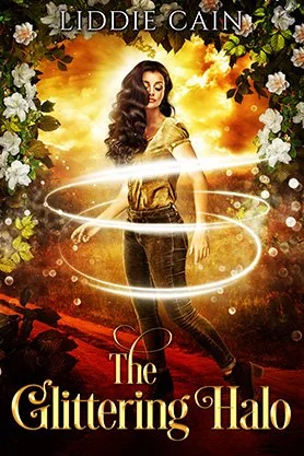 Paranormal fantasy book cover for “The Glittering Halo” by Liddie Cain, featuring a woman surrounded by glowing white light and flowers against a golden background.