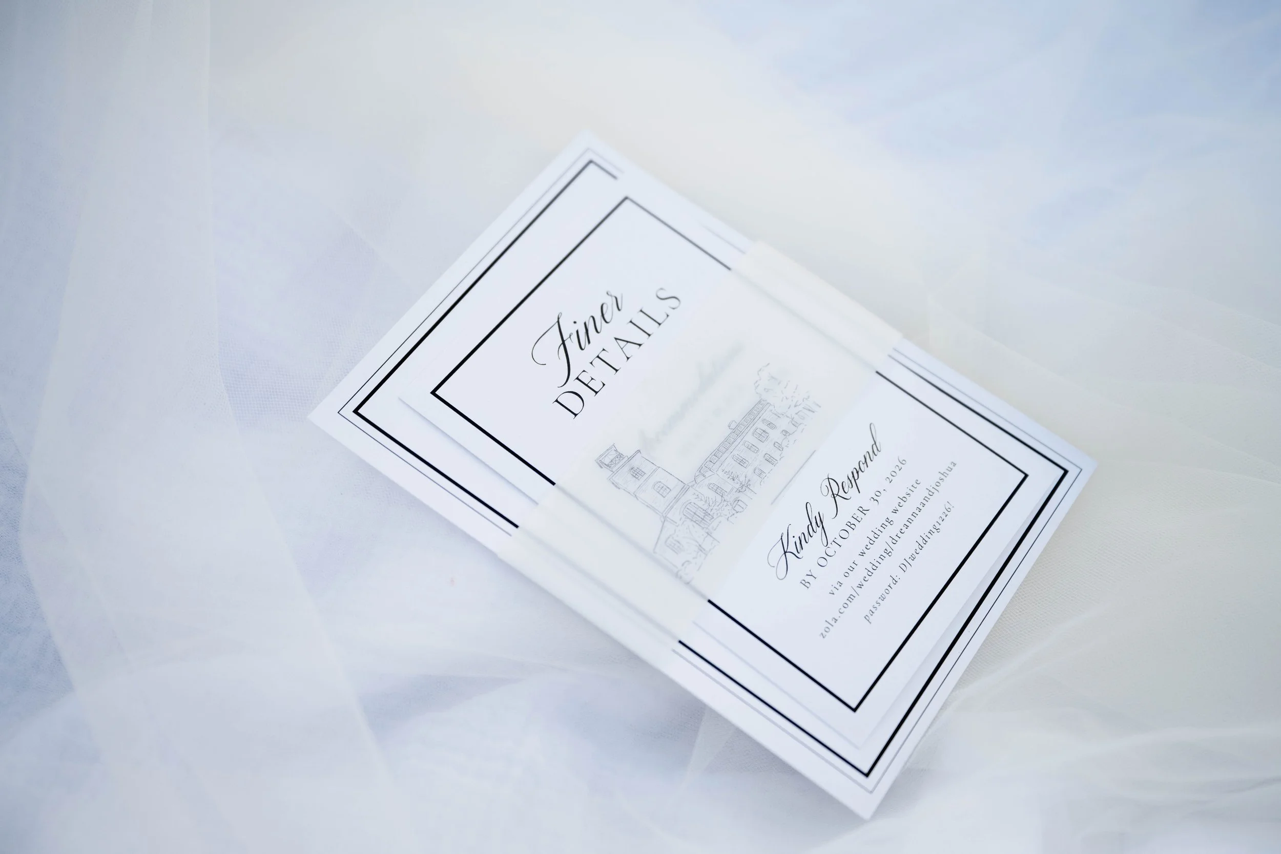 Wedding invitation card with black border and elegant script, placed on a white surface.
