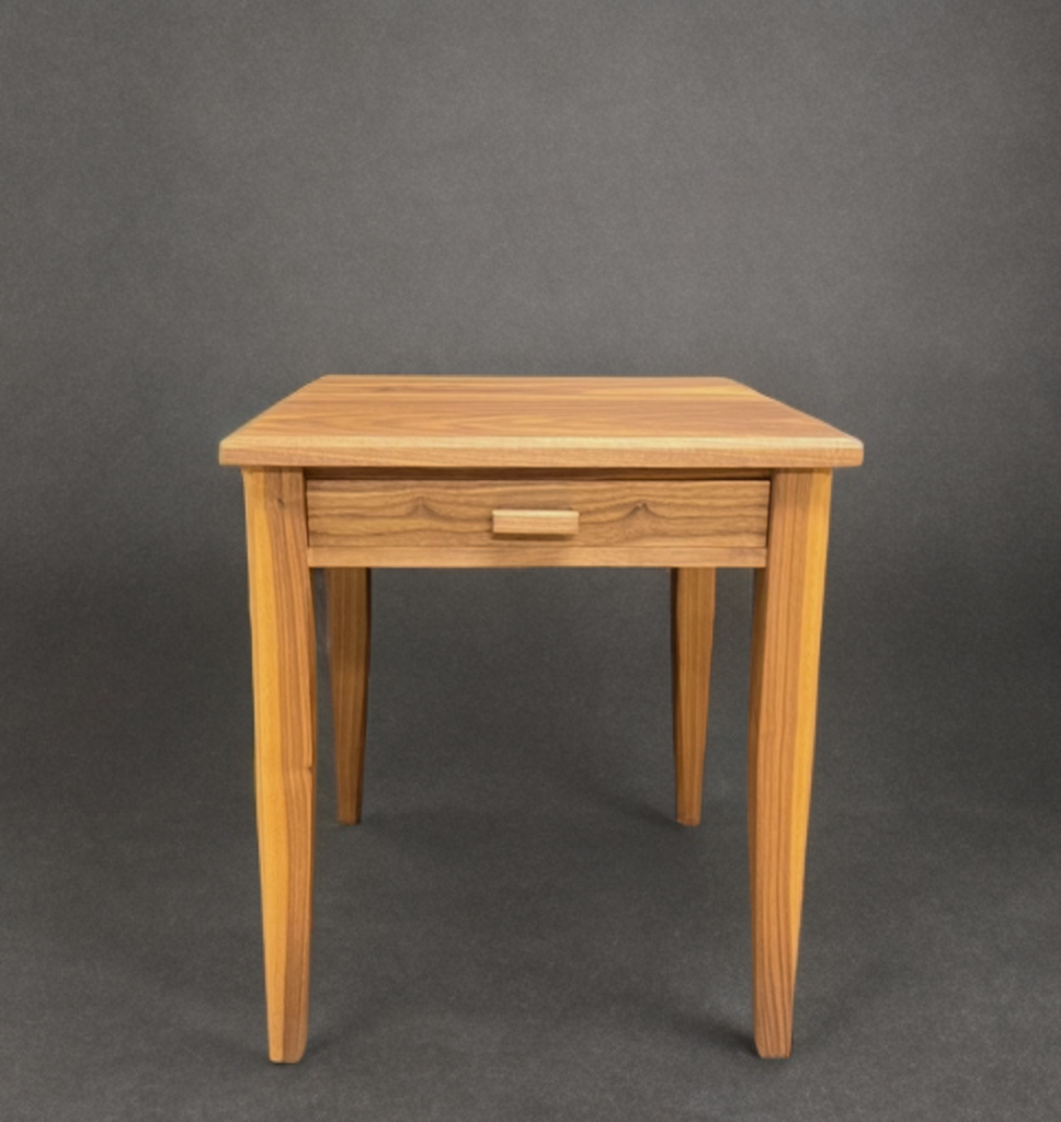A small wooden table with a drawer on a dark background.