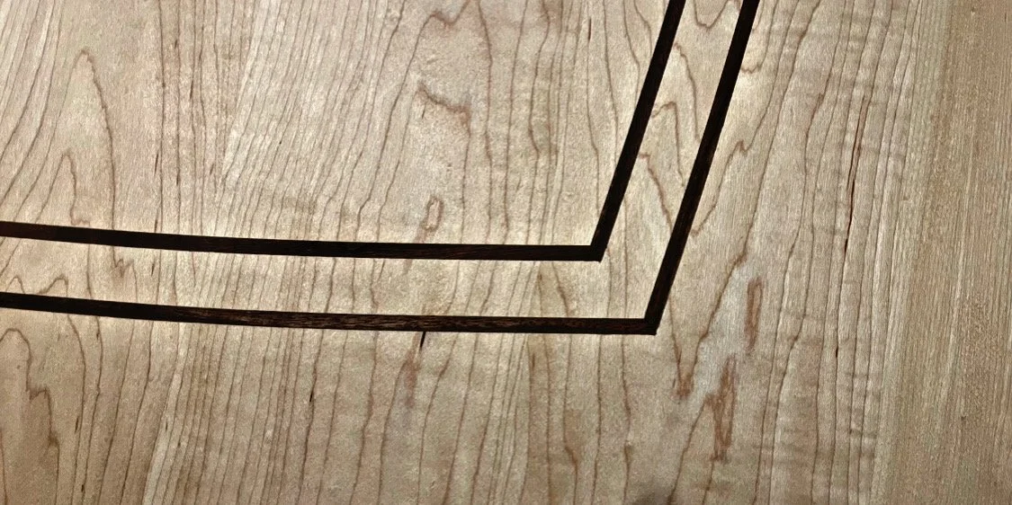 Close-up image of a wood surface with a dark border.
