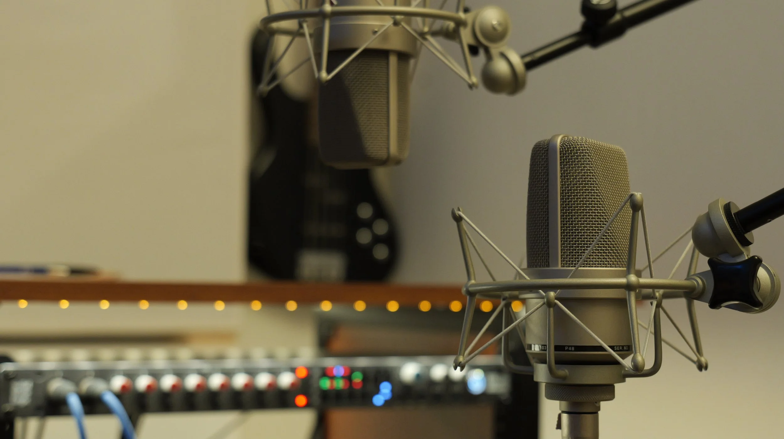 Deux microphones stationnaires dans une cabine d'enregistrement, avec un équipement audio visible au premier plan.