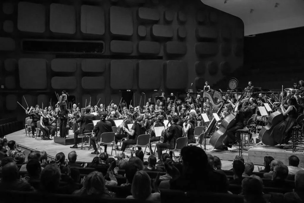 Orchestre symphonique en performance dans une salle de concert.