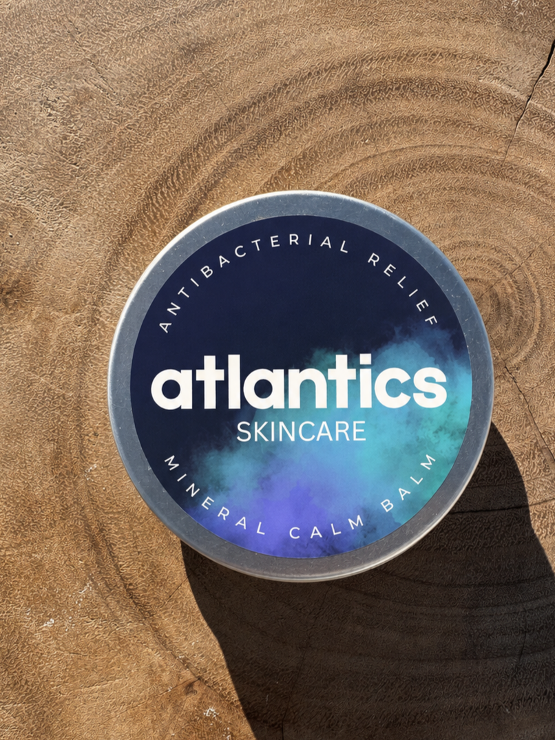 Round container of Atlantic Skincare with a mineral calm balm label on a wooden surface.