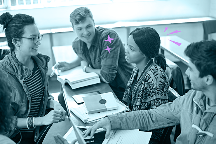 Group of four diverse students studying and discussing at a table in a classroom.