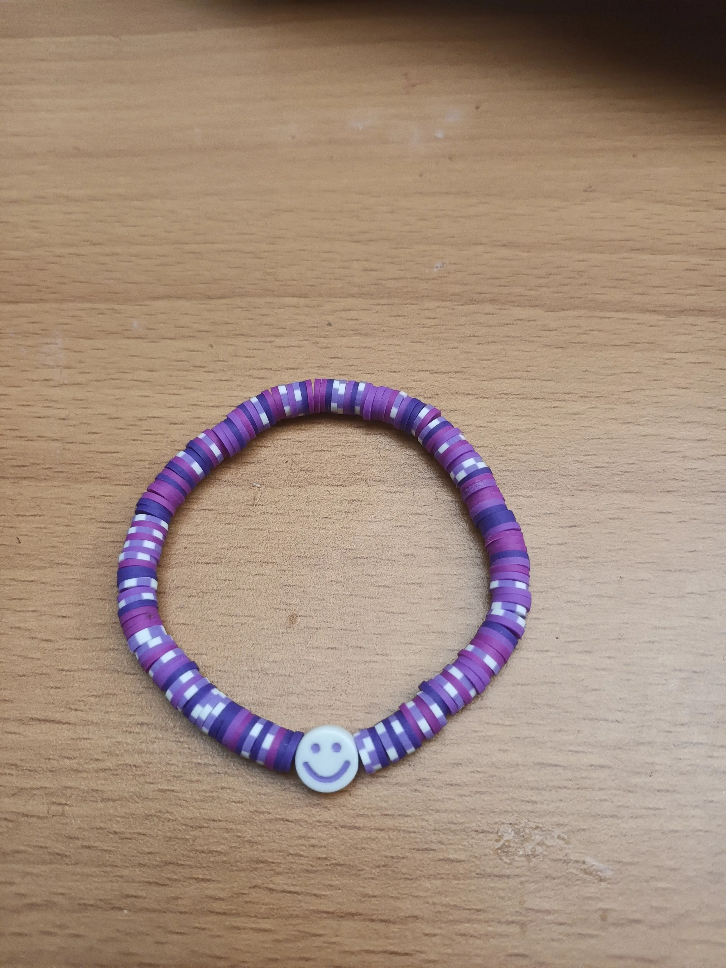 Purple braclet with white smiley face