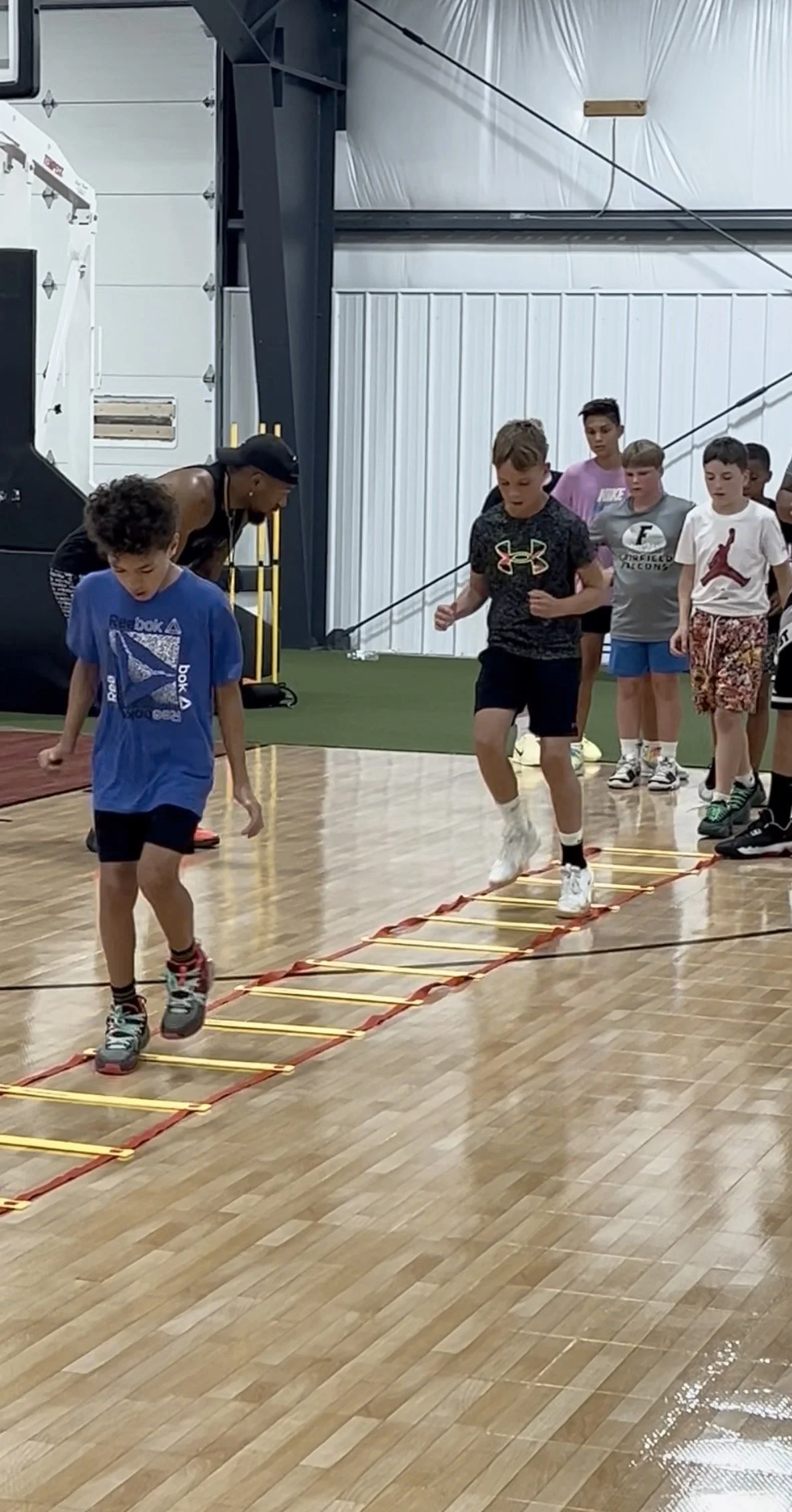 Children participating in agility training during a Gary Family Foundation youth sports program.